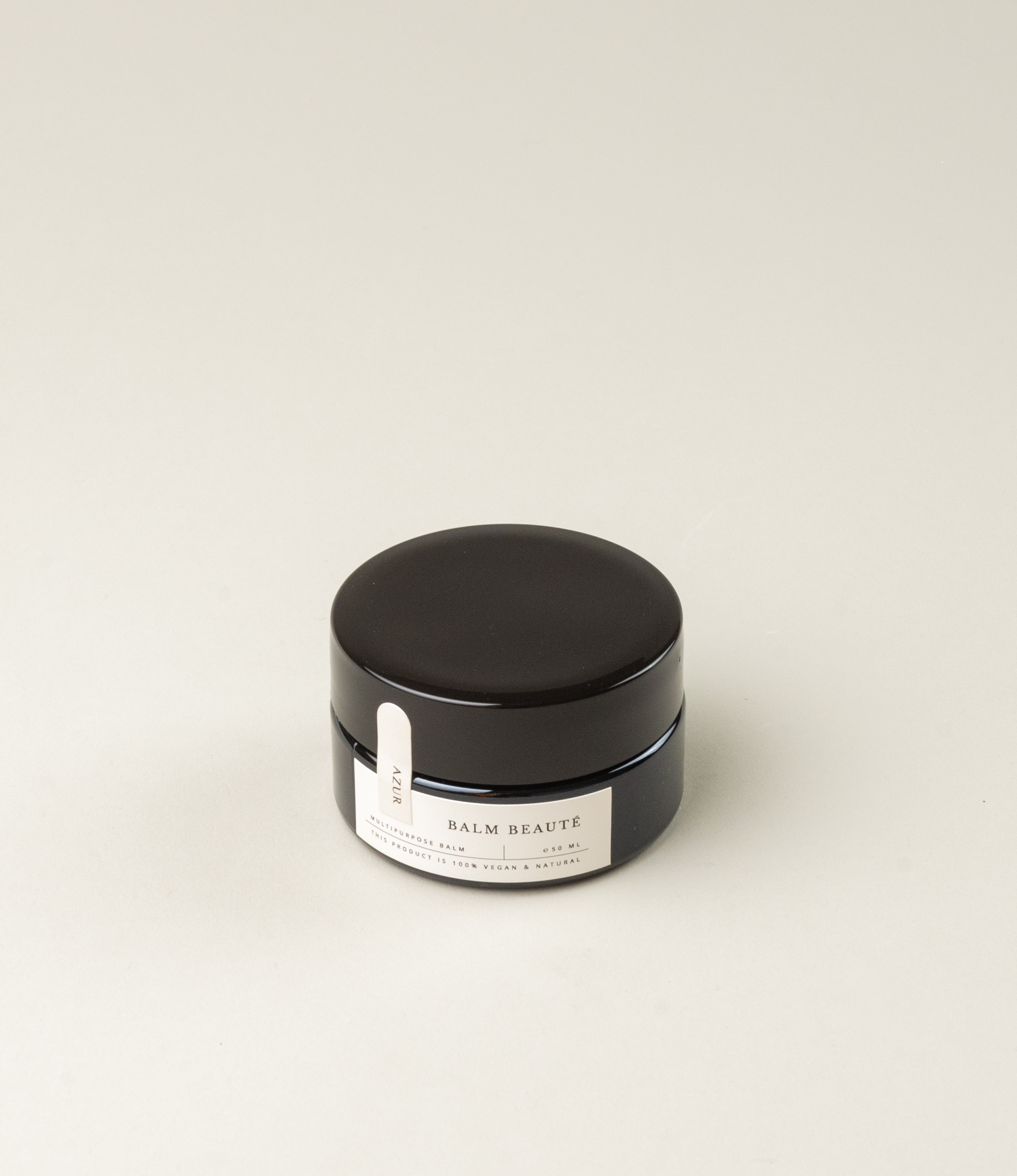 Multipurpose balm from Azur Natural Body Care. The balm comes in a black elegant tin. The balm itself has a pale vanilla color.
