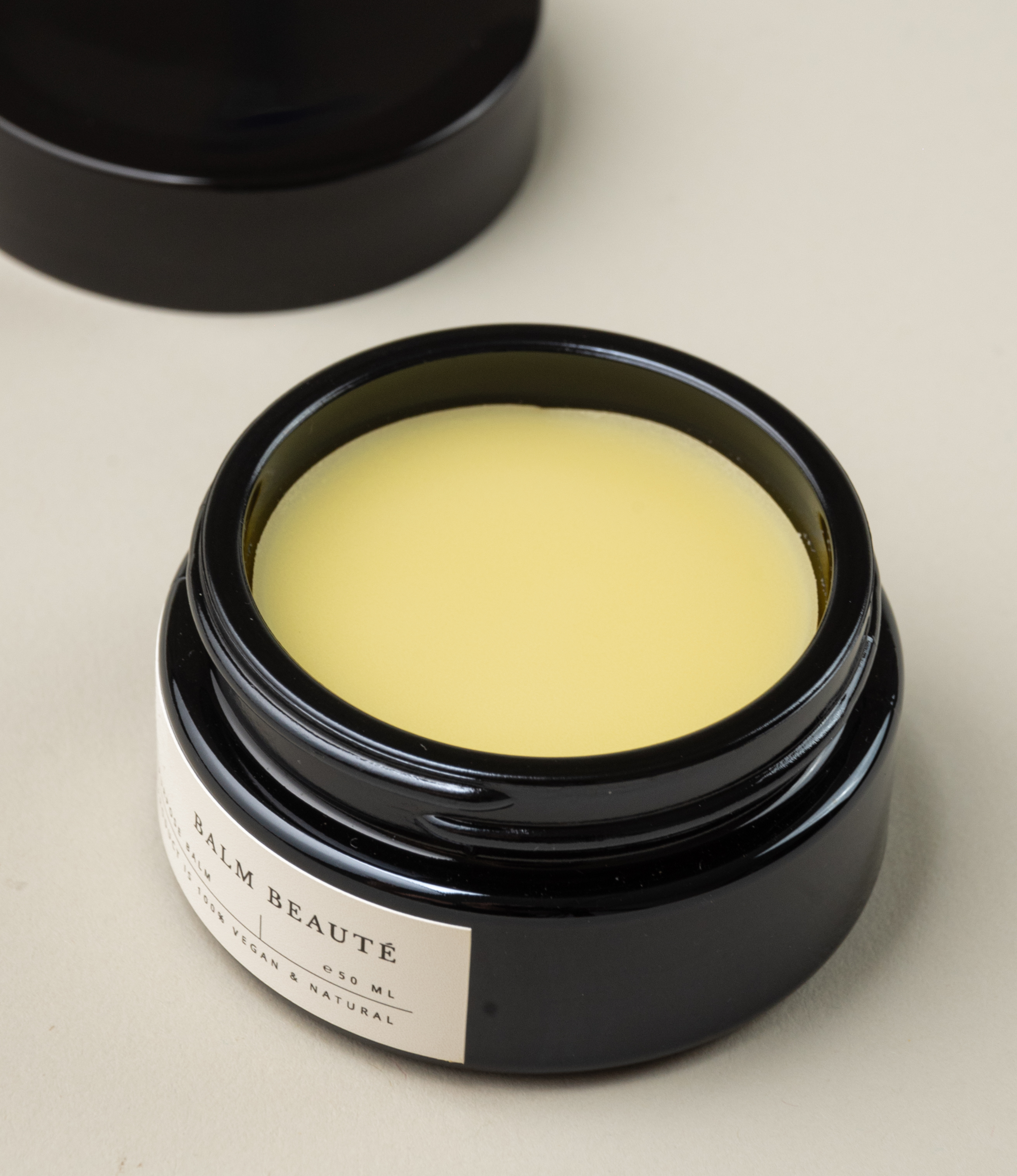 Multipurpose balm from Azur Natural Body Care. The balm comes in a black elegant tin. The balm itself has a pale vanilla color.