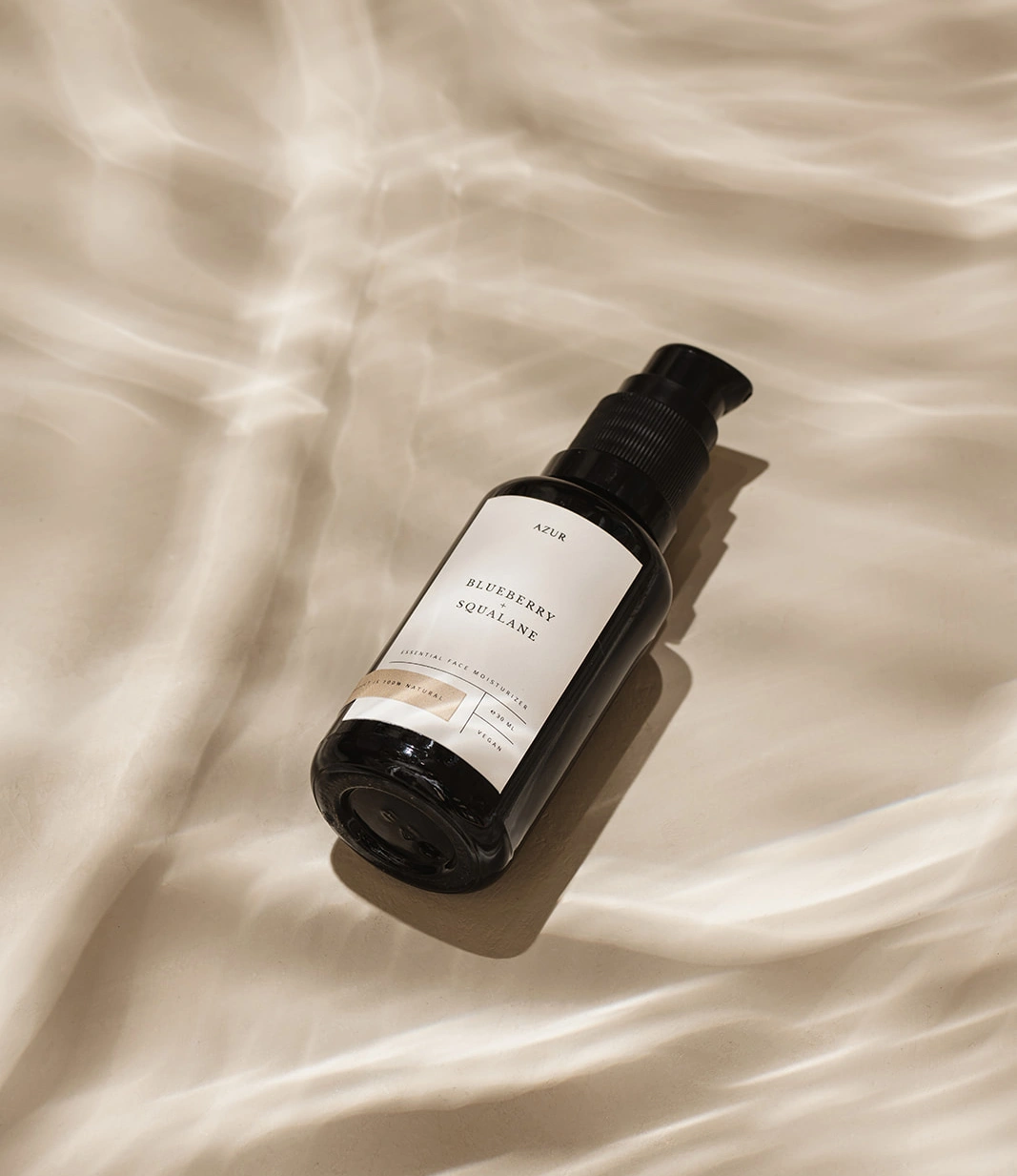 Face Oil from Azur Natural BodyCare. The product looks as if it was underwater with a beautiful lightning around it.