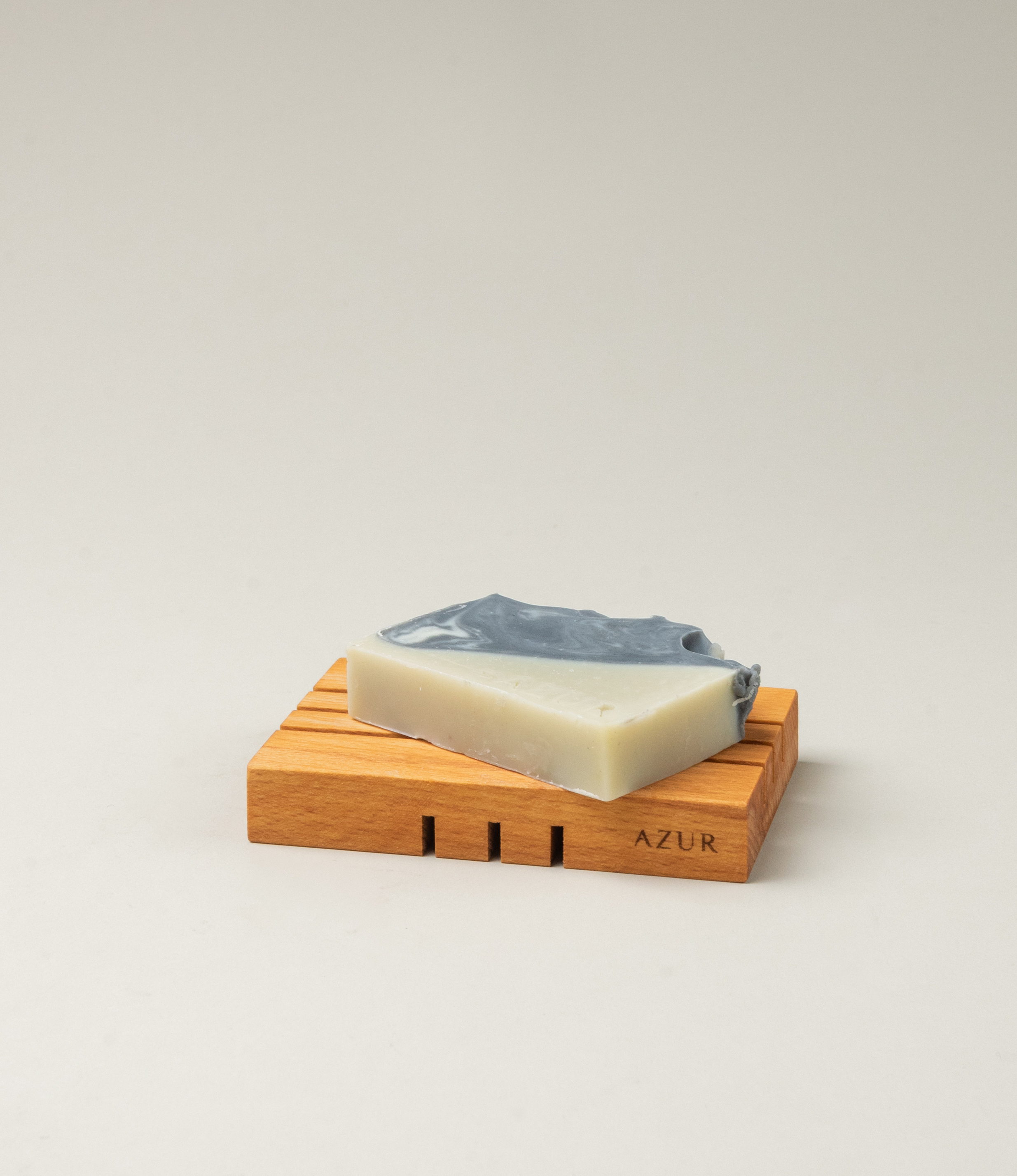 This soap has the scent of Wild Woods and it was crafted by Azur Natural Bodycare. The product merges two colors, light olive and dark grey. The top of the soap looks like the waves of the ocean. 