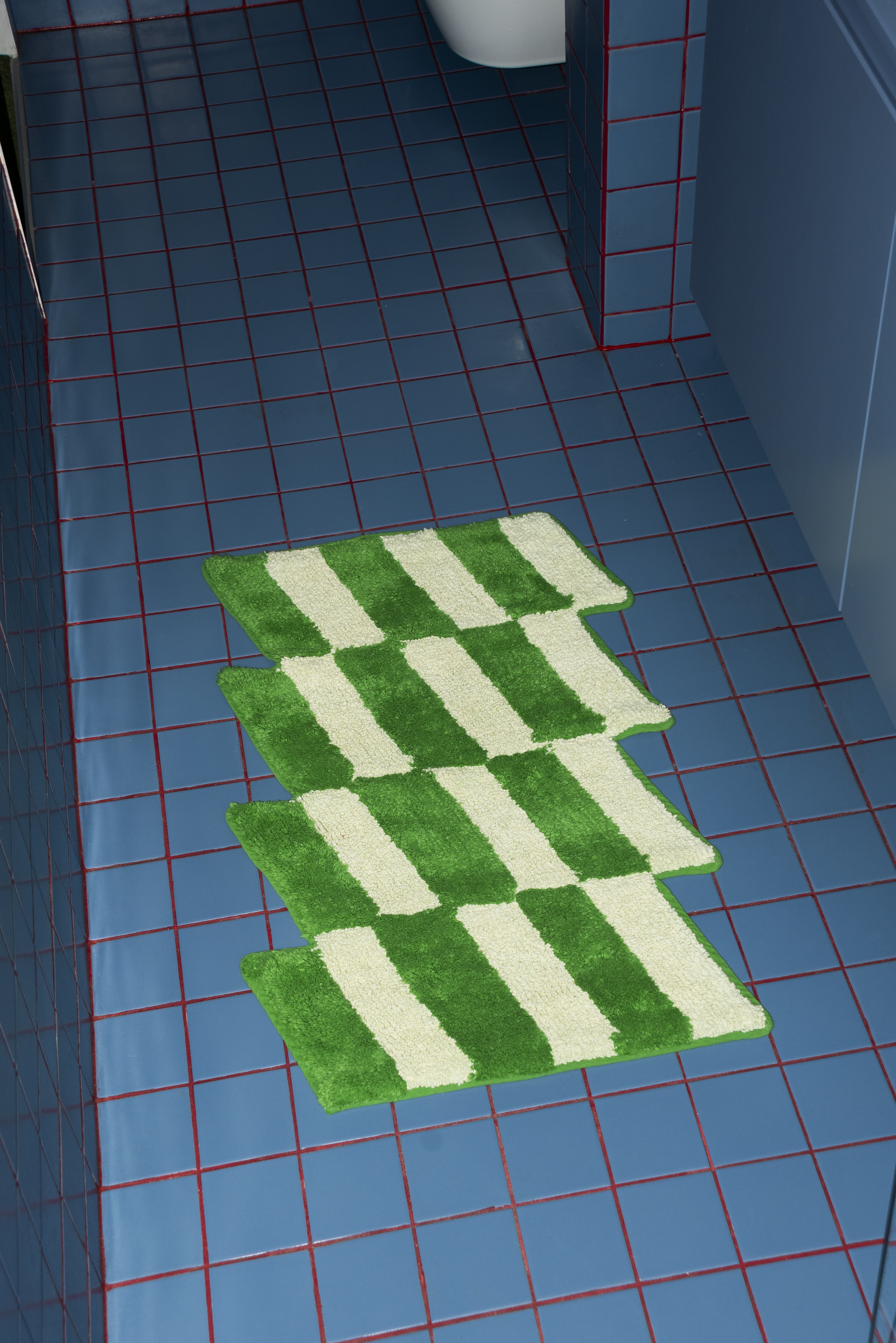 A closer look at the Casette Bathmat by Tarta Gelatina in use, styled on a tiled floor, showing its plush texture and contemporary geometric design.