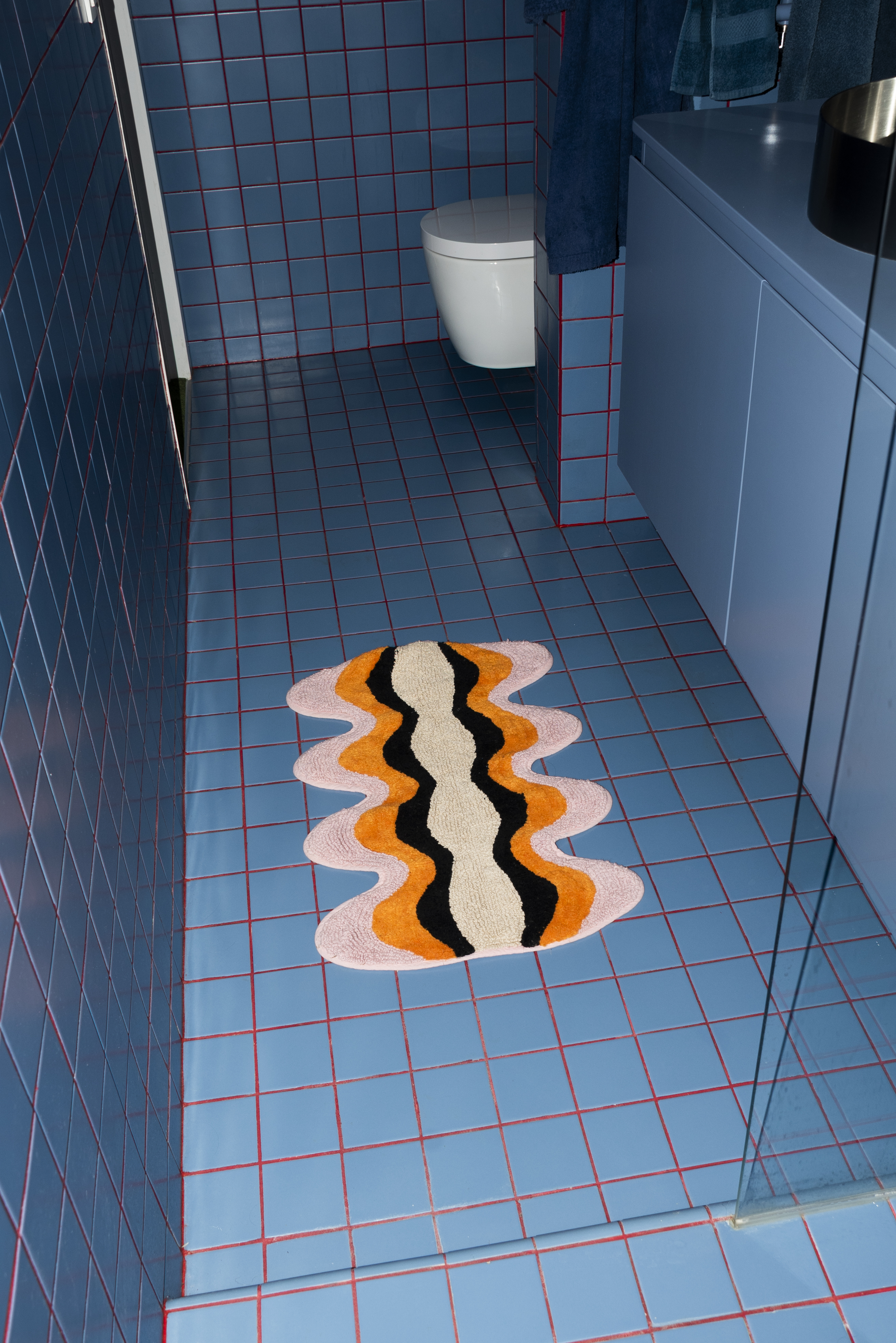 Tarta Gelatina Plankton Bathmat in use, styled on a tiled floor, showing its sculpted edge and vibrant design against a contemporary interior.