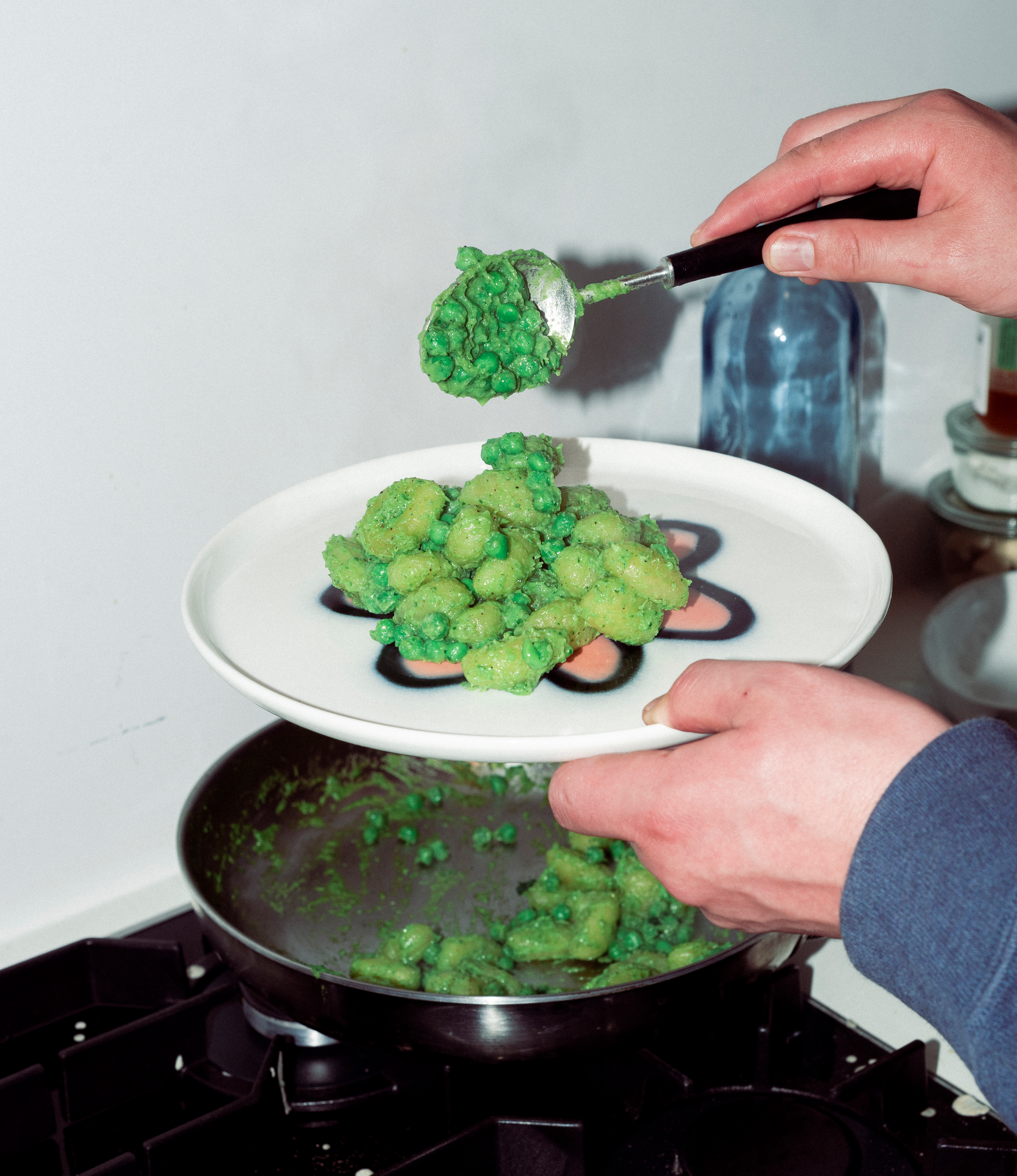 Frizbee Ceramics' Peach Carne Plate hold by a hand and serving gnocci with peas and guanciale.
