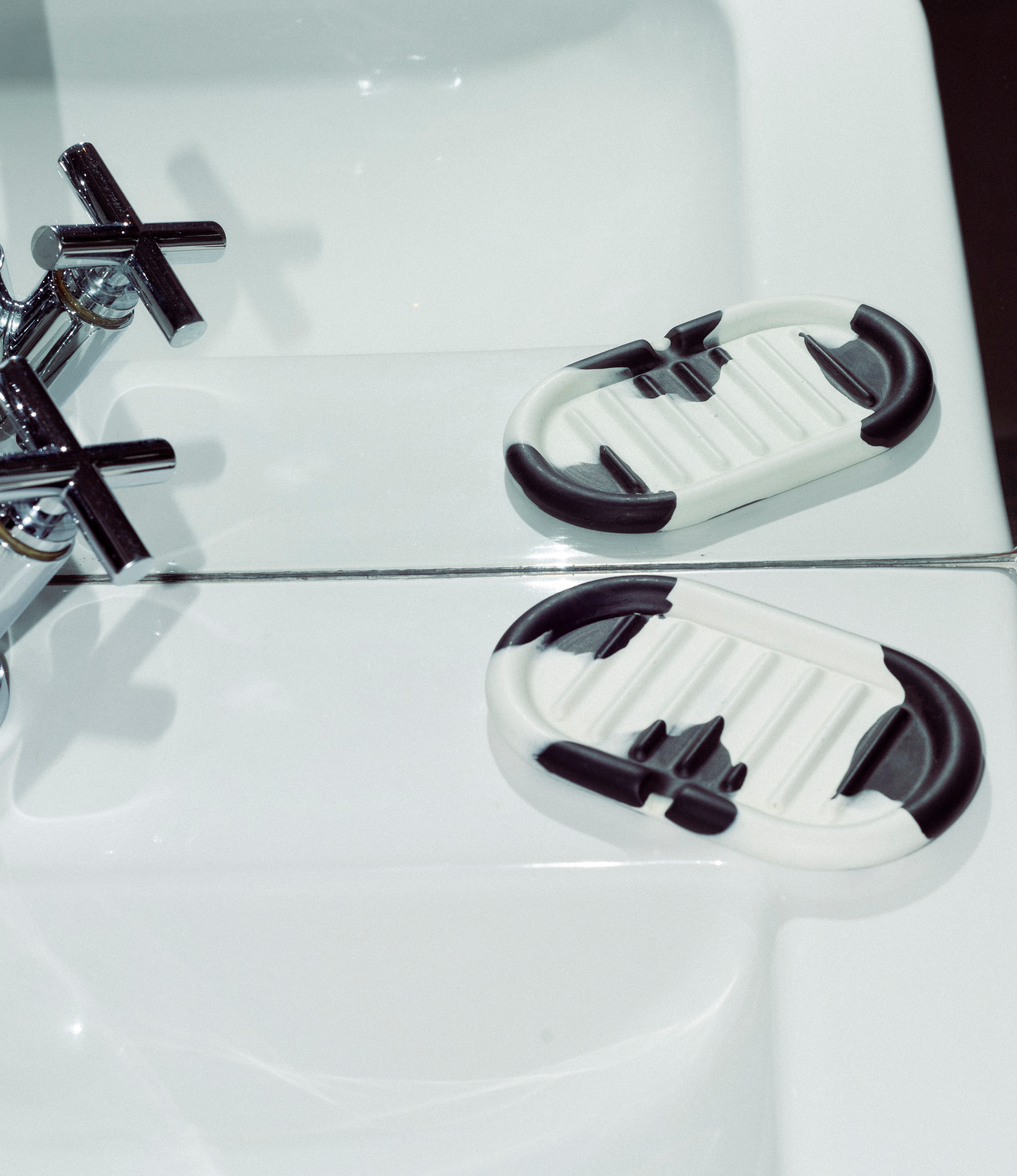 Soap Holder from Gritful Homeware in the maximalist color pairing of light rose and orange. The soap dish has a rounded shape which matches the pattern of the item, which is very much organic. The product is placed on a white bathroom sink.