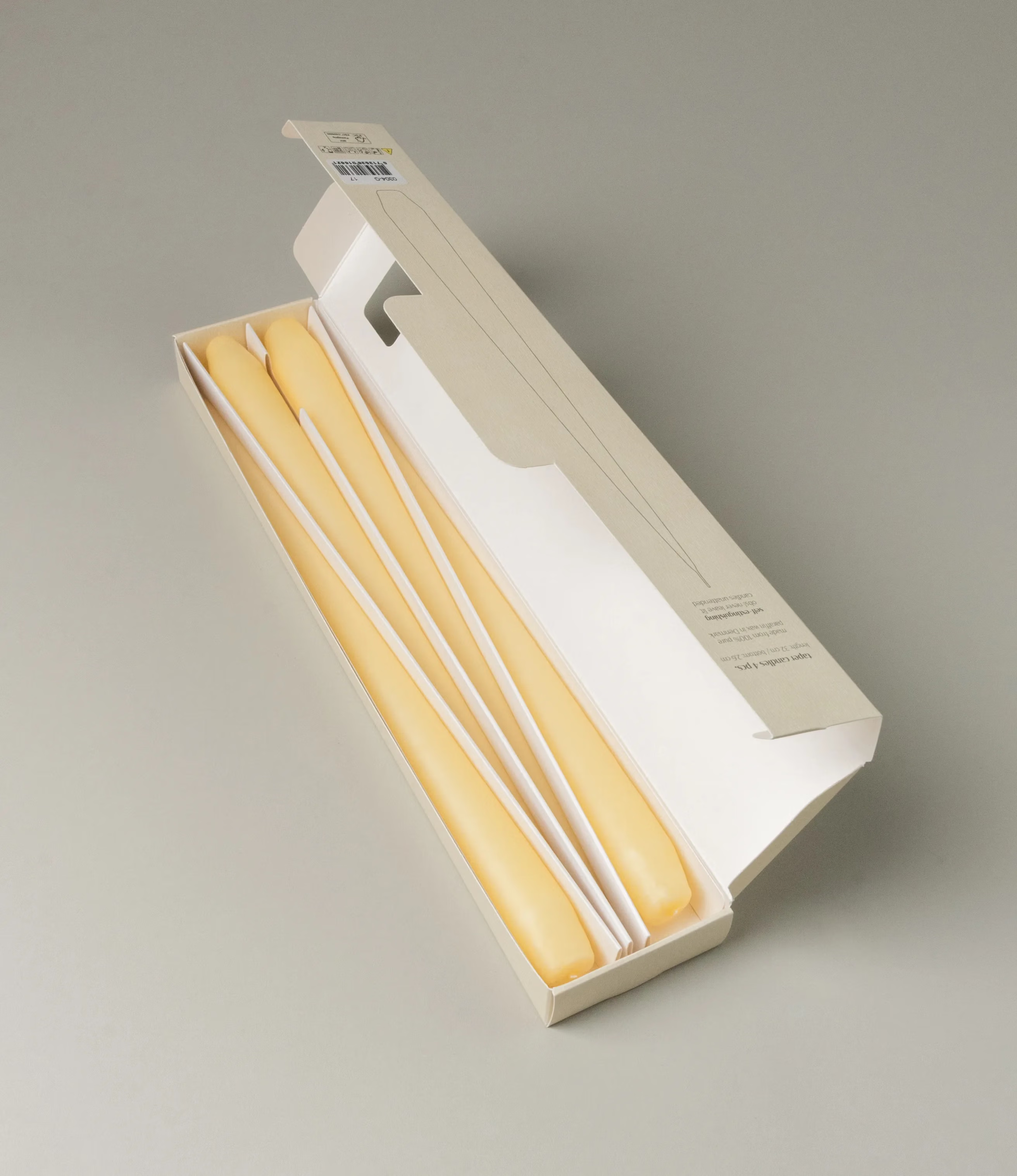 Ester&Erik Taper Candle coming in a Buttermilk shade. The package contains 4 taper candles of the same shade. The packaging has a warm white color, and elegant minimalistic design.