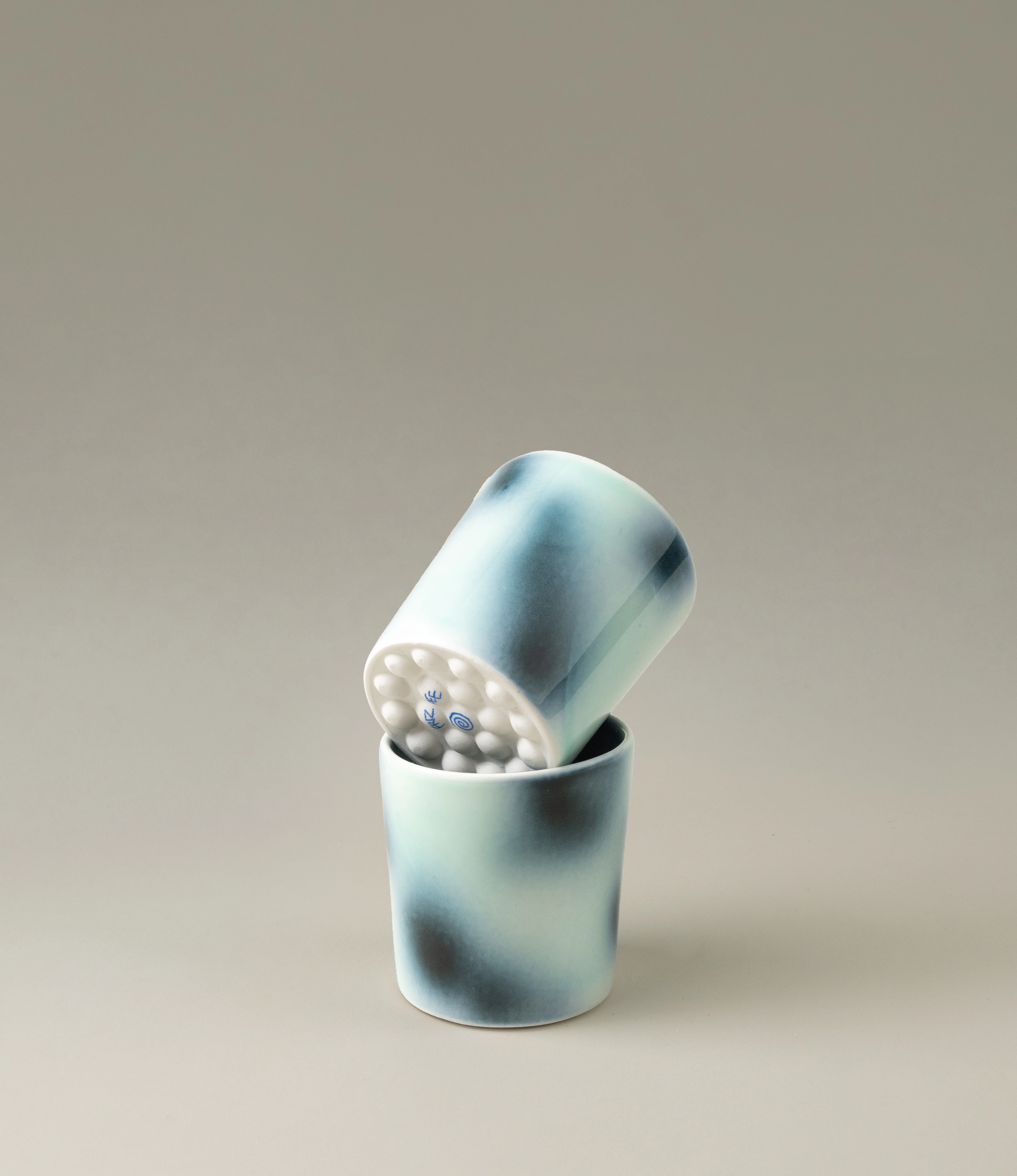 Bulle Cup from Frizbee Ceramics has a unique gradient painted pattern. The product which comes in a set of two, has cold colors like green, dark and light blue. The bottom of the cup looks like it's made of small bubbles.