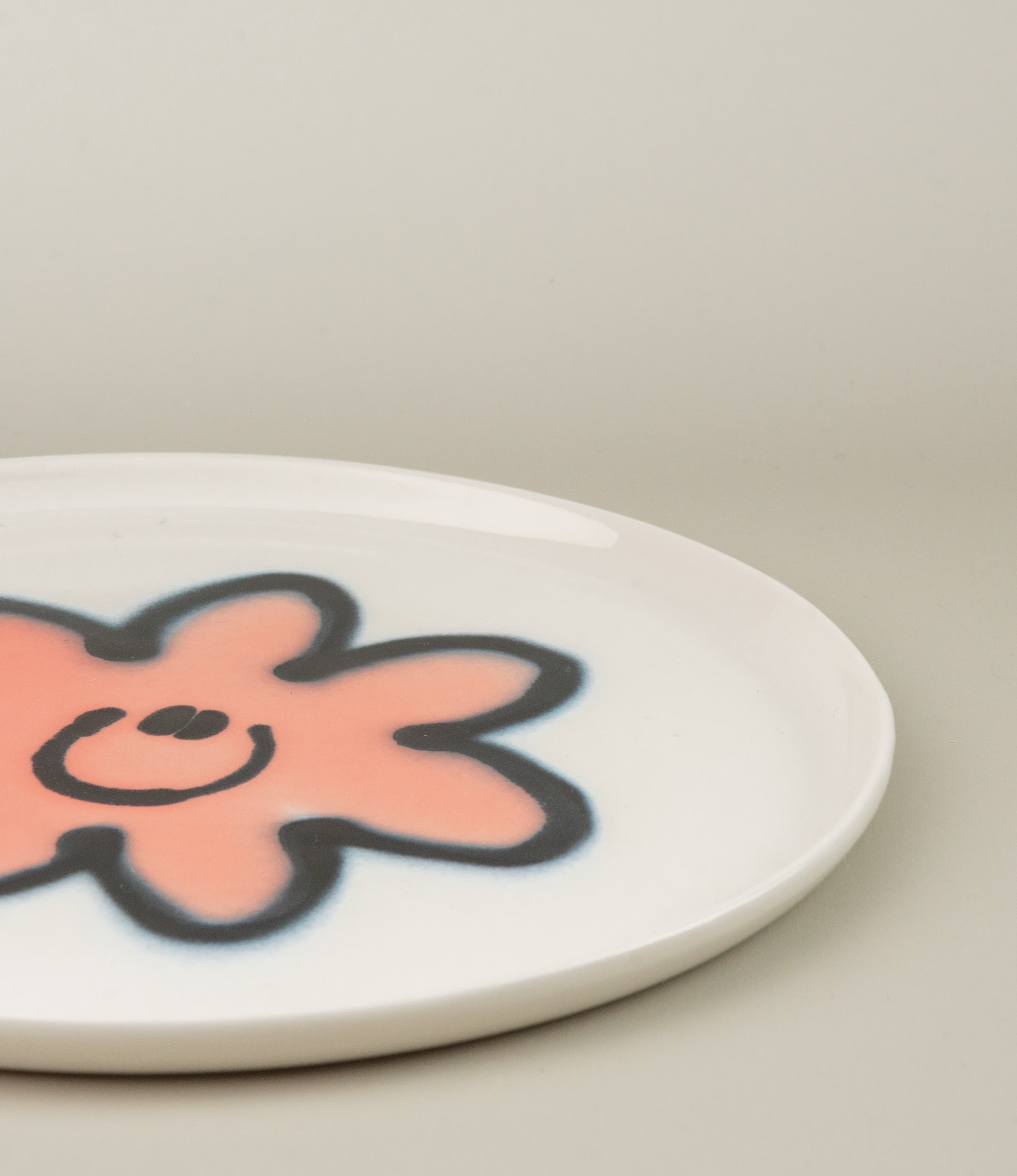 Frizbee Ceramics' Plate coming with the Peach Carne pattern on a white base. The picture shows a closeup of the product.