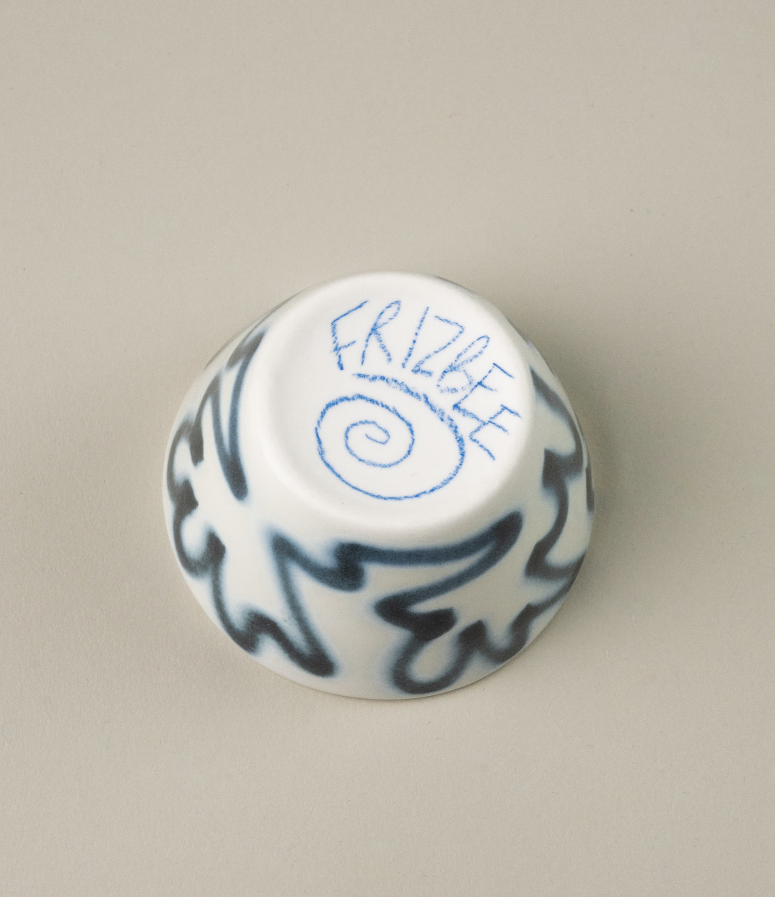 The bottom of the product has a unique hand drawn logo of the designer, Frizbee Ceramics.