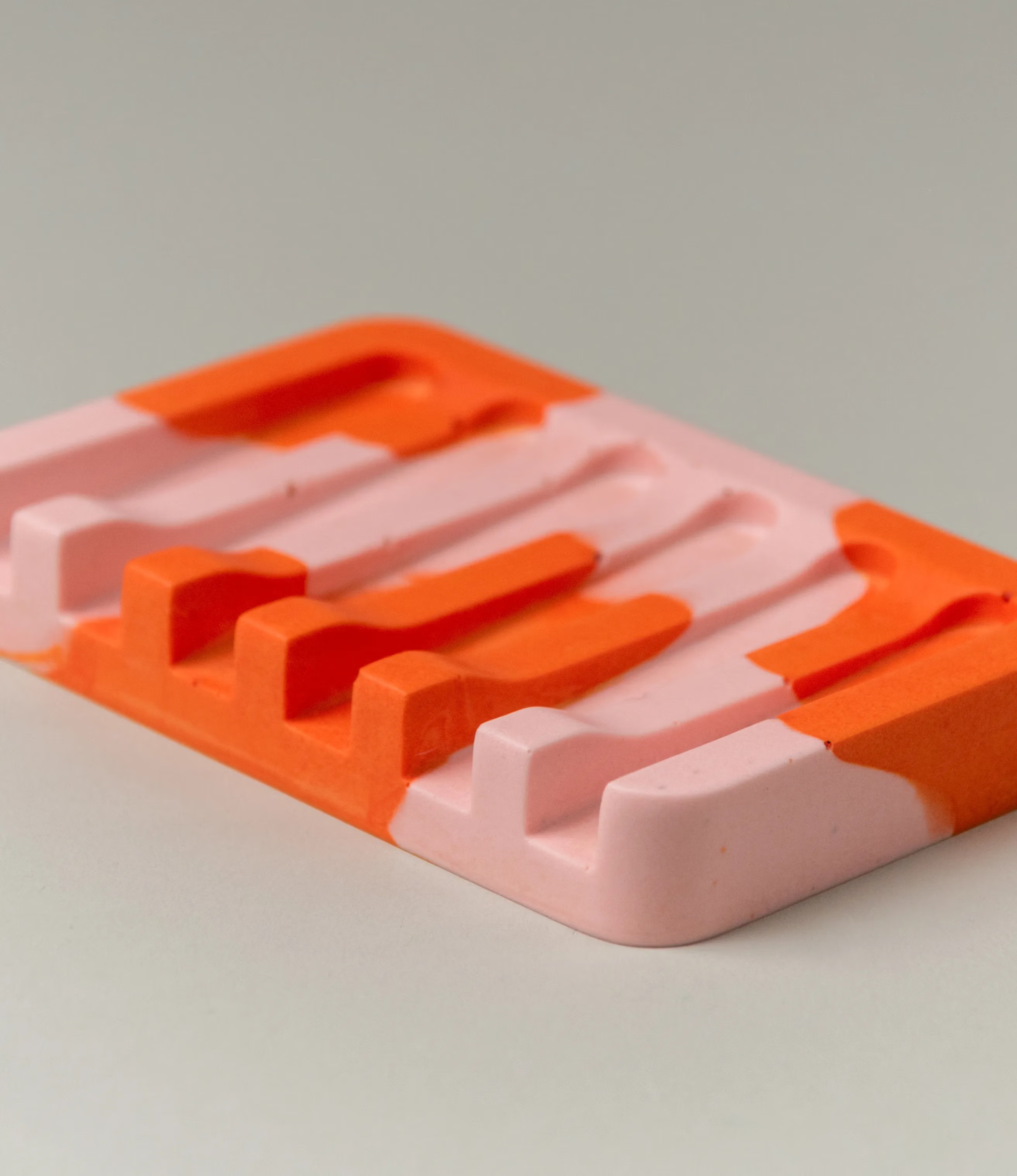 Soap Holder from Gritful Homeware in the maximalist color pairing of light rose and orange. The soap dish has a rectengular shape which contrasts the pattern of the item, which is more organic. This picture shows the details of the product