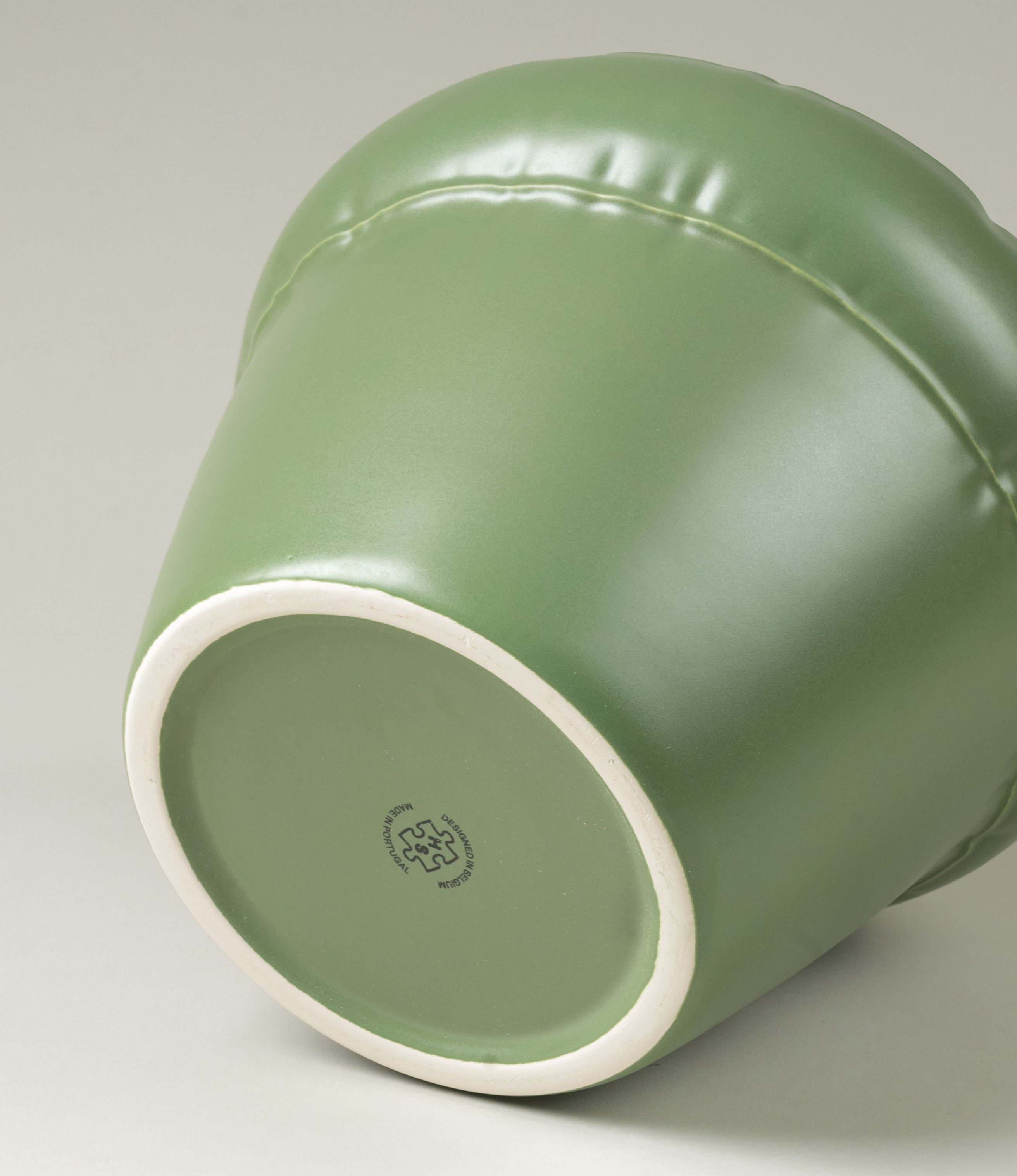 The bottom of Homestudyo's planter Pierre in moss color.  the planter design looks like and inflatable ballon although it is made of ceramics.