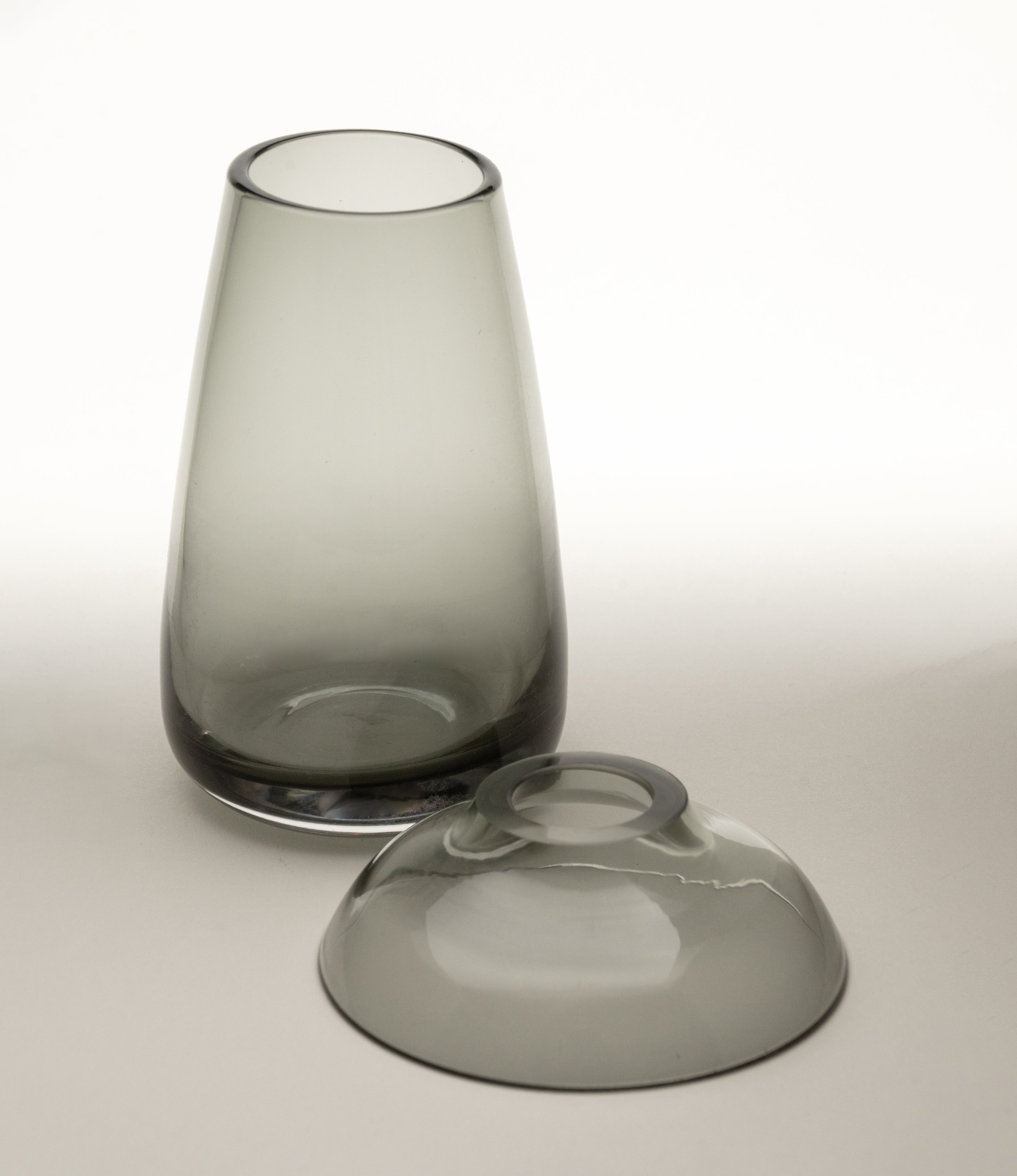 Aqua Culture Vase small from Kinto is a vase to grow new plants. The vase consists of two pieces, a base and a dish for the top, which holds the bulbs, seeds or leaves. This variant is made of a gray glass.