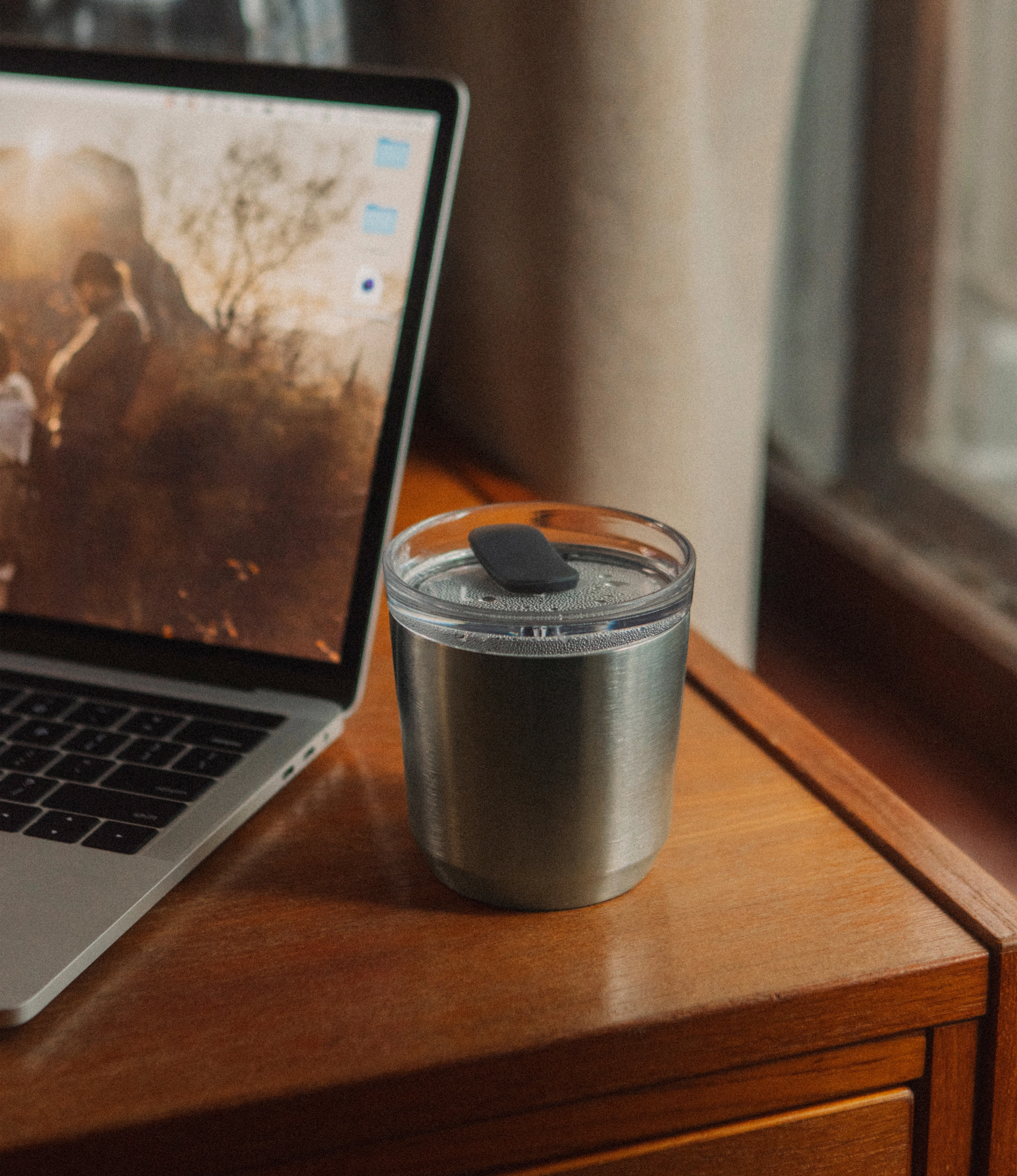 To Go tumbler Stainless Steel in use. The product is placed on an office table, next to a laptop.