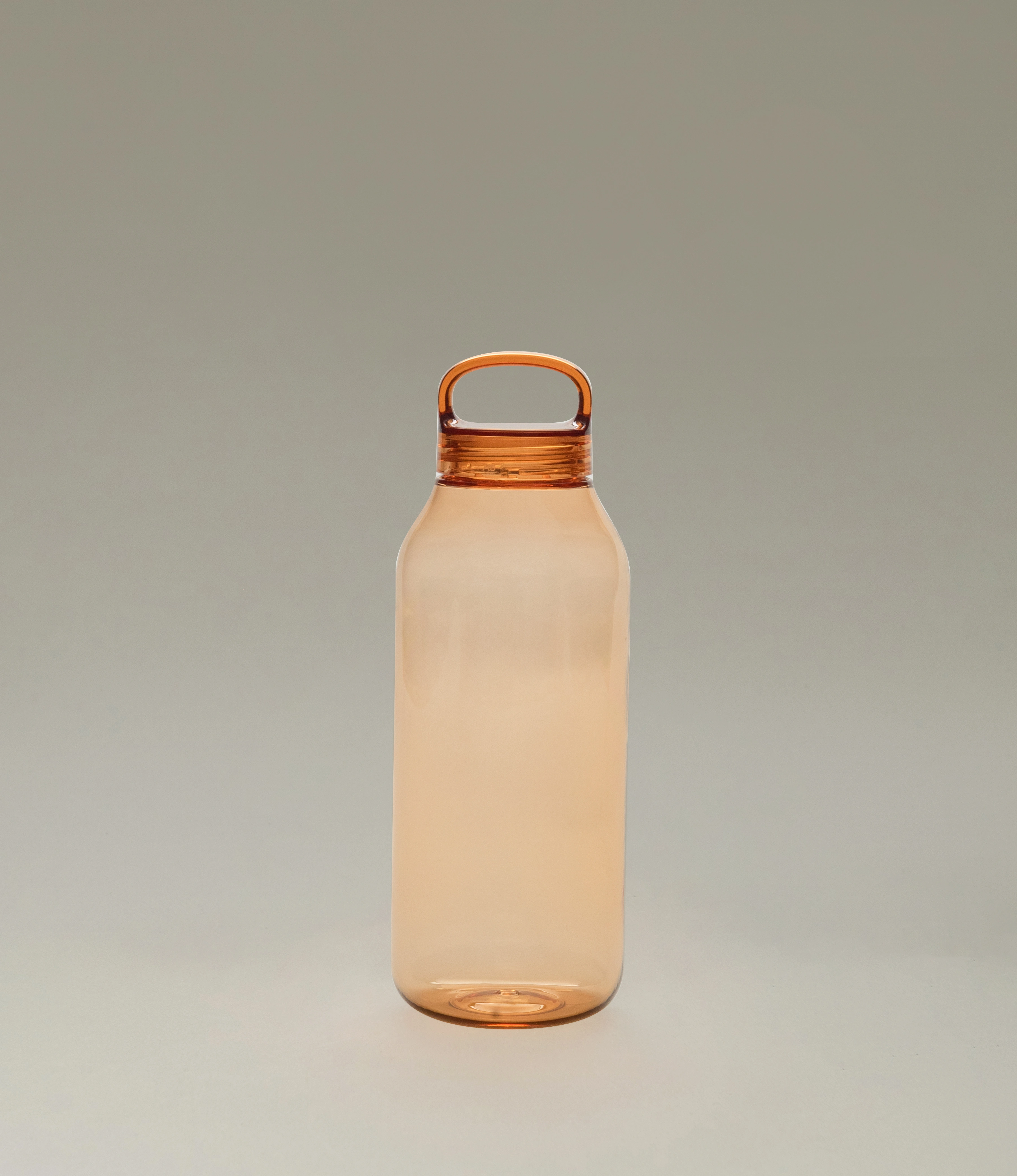 A sleek amber-colored water bottle with a minimalist design and a rounded handle integrated into the cap. The bottle sits on a soft neutral background, emphasizing its translucent material and modern aesthetic.