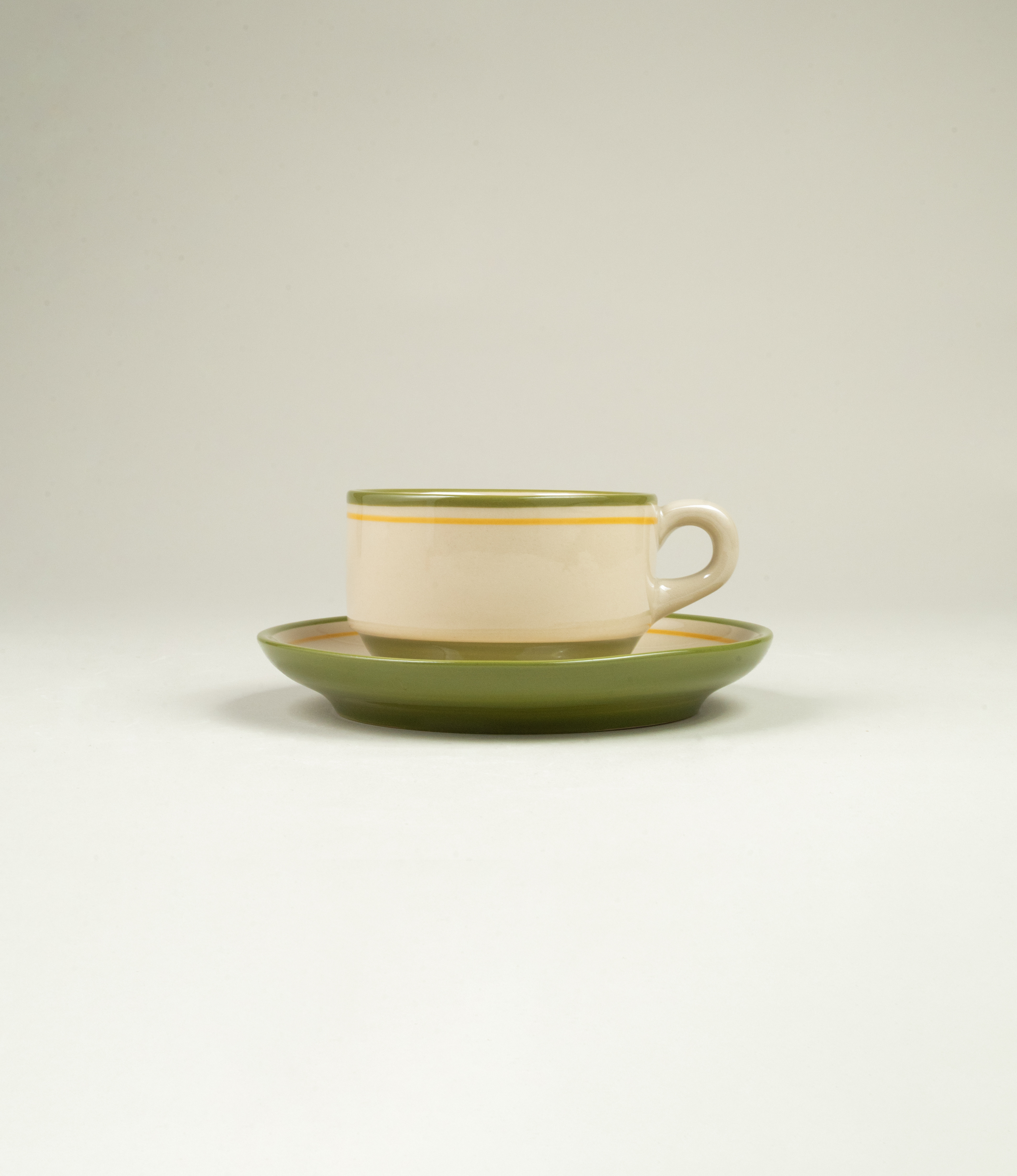 Casa Atlântica green stoneware coffee cup and saucer with hand-painted yellow and green rim, inspired by vintage Spanish bar cups.