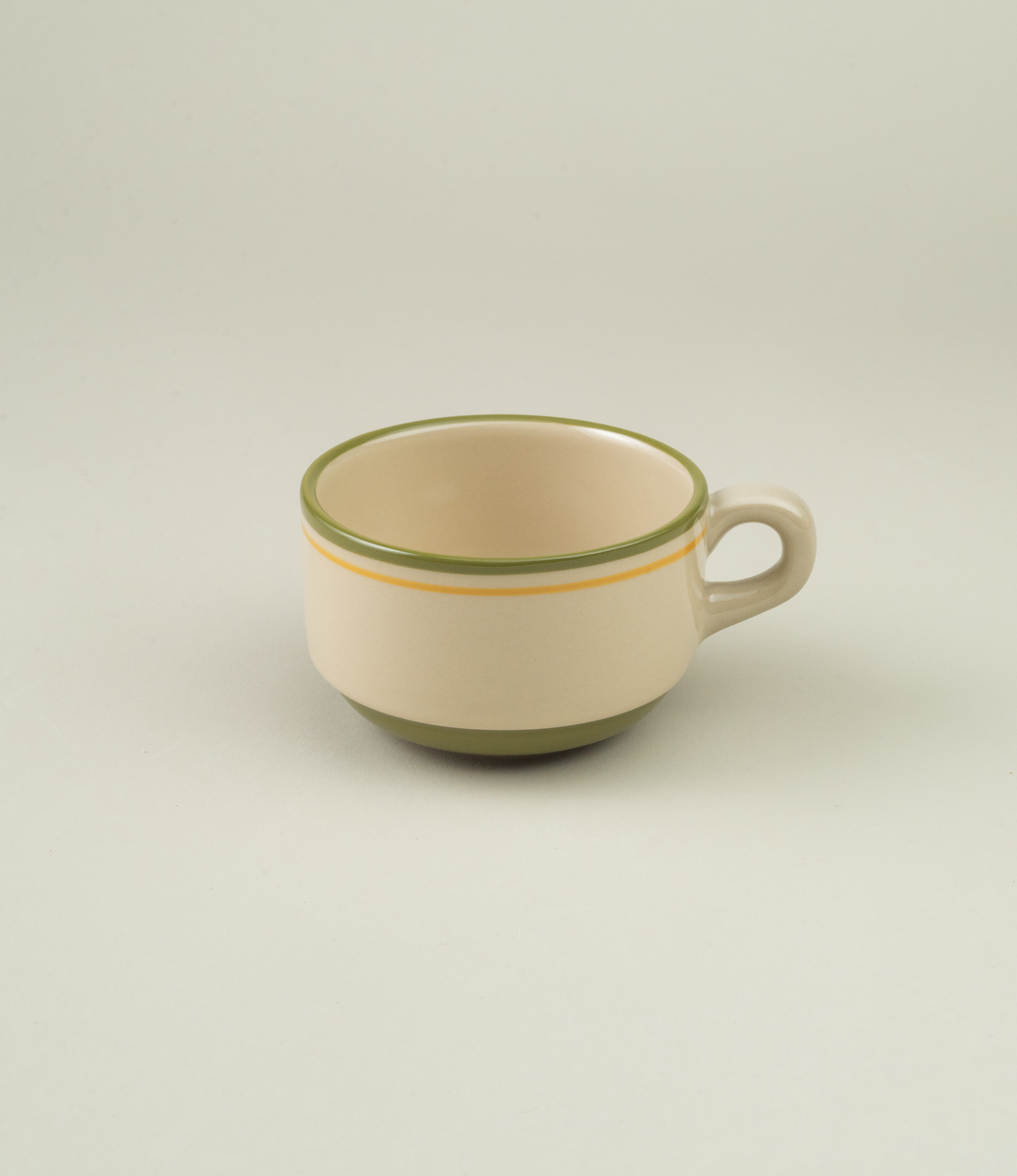 Casa Atlântica green stoneware coffee cup shown upright without saucer, highlighting minimalist form and hand-painted finish.