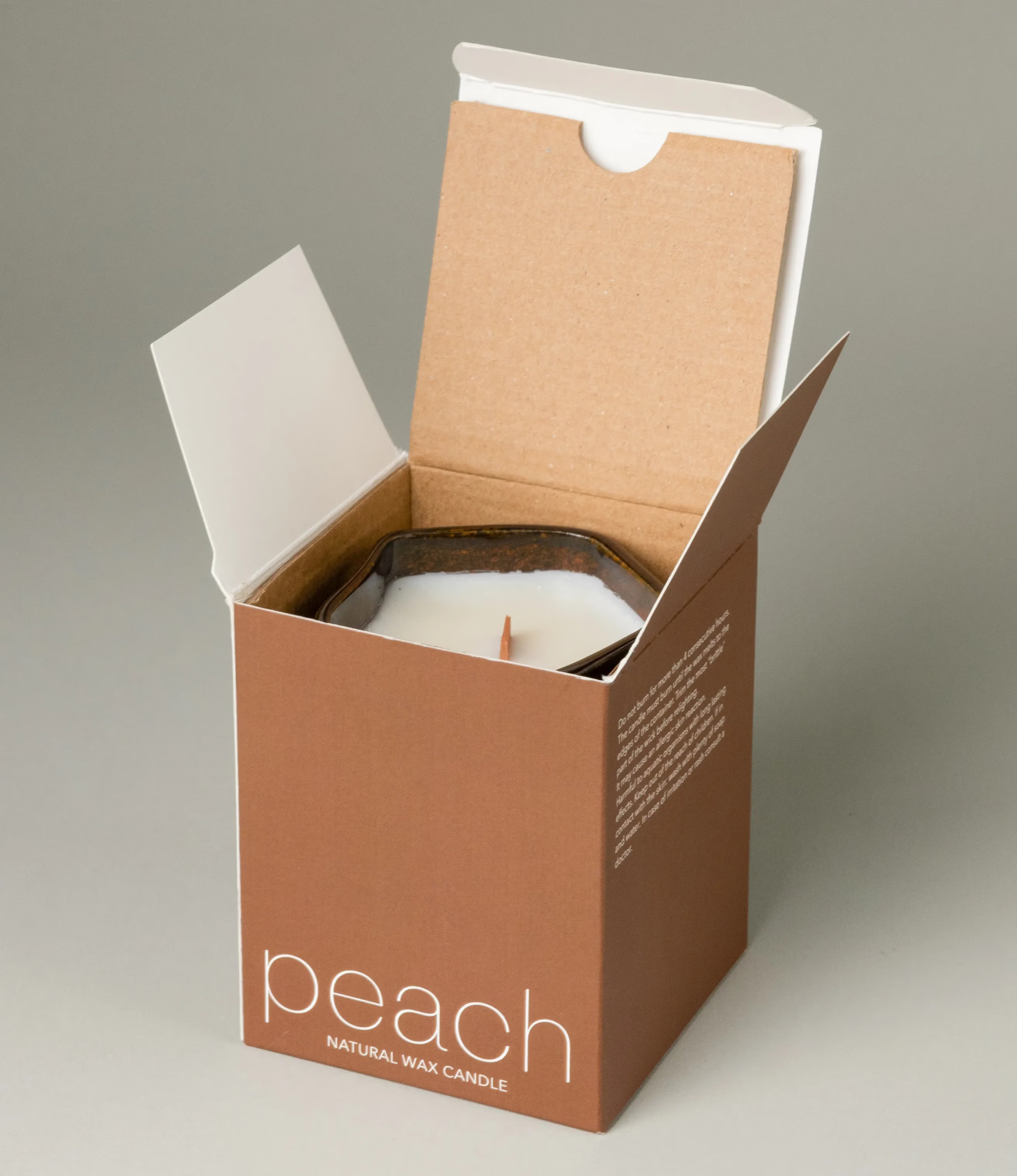 A scented Wax Candle designed by Ocactuu. The candle has a peach scent and it comes in a glossy dark brown ceramic. The material has a subtle spotted texture. The candle wick is made of wood for a more natural feeling.  