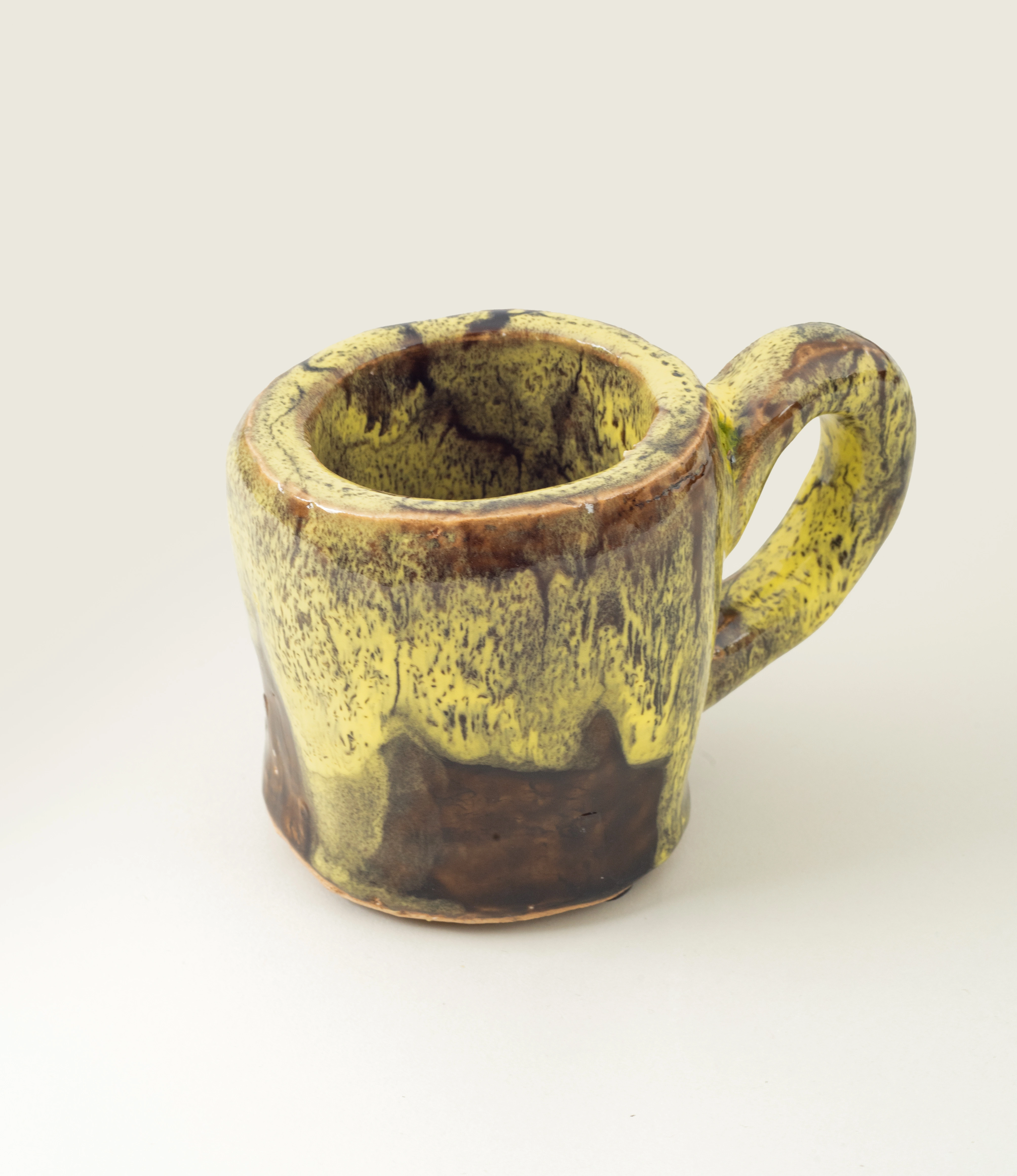 Cafeflamengo decorative cup from Serax. The cup is not suitable for drinking from it but can be perfect to store items on your desk. The cup has a special glazing with a dripping effect on it. The base of the cup is brown and the dripping is yellow. The item is handmade.