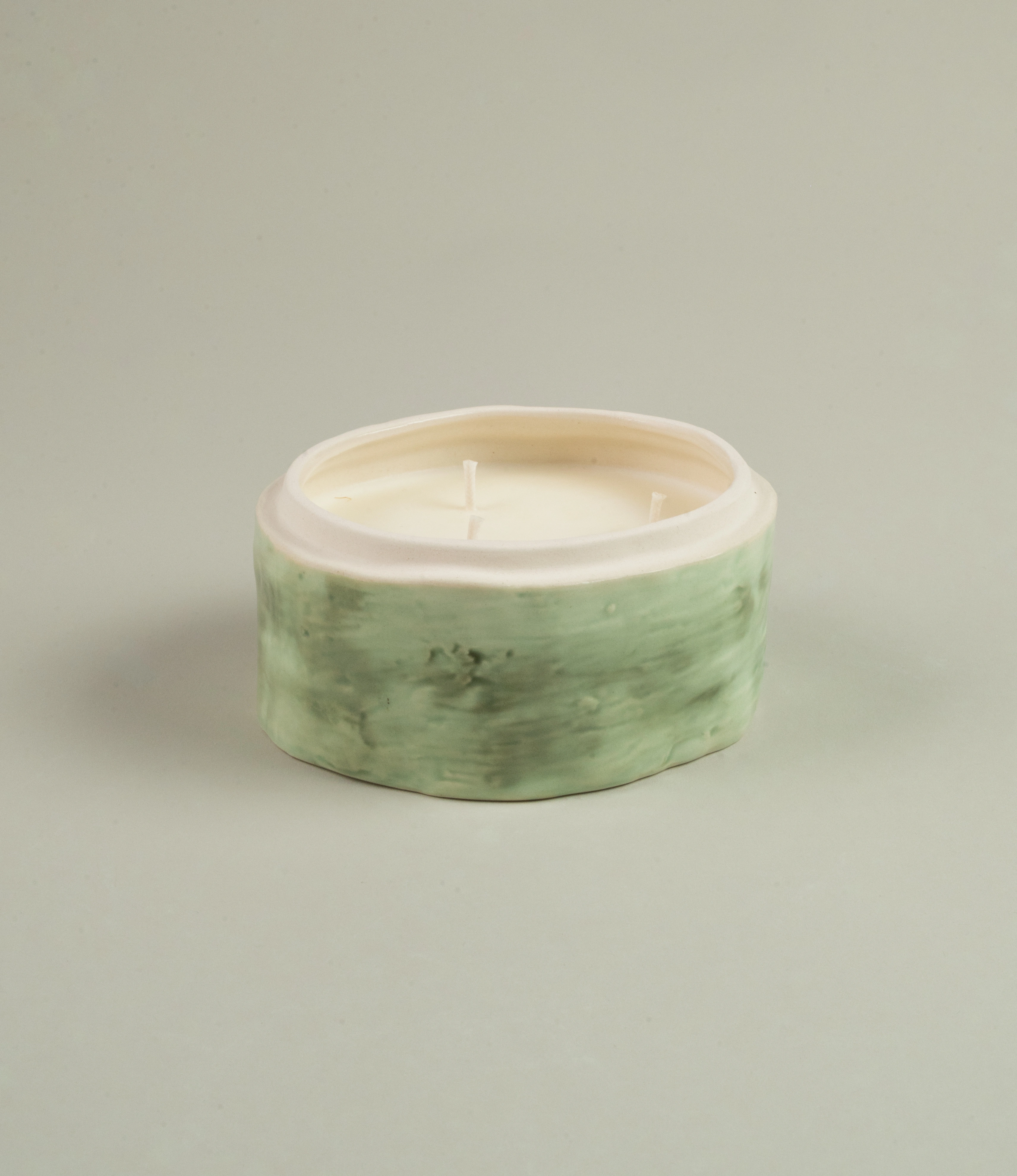 Serax Green Sonata medium-sized candle showcasing its green ceramic container filled with white wax, set on a neutral light background.