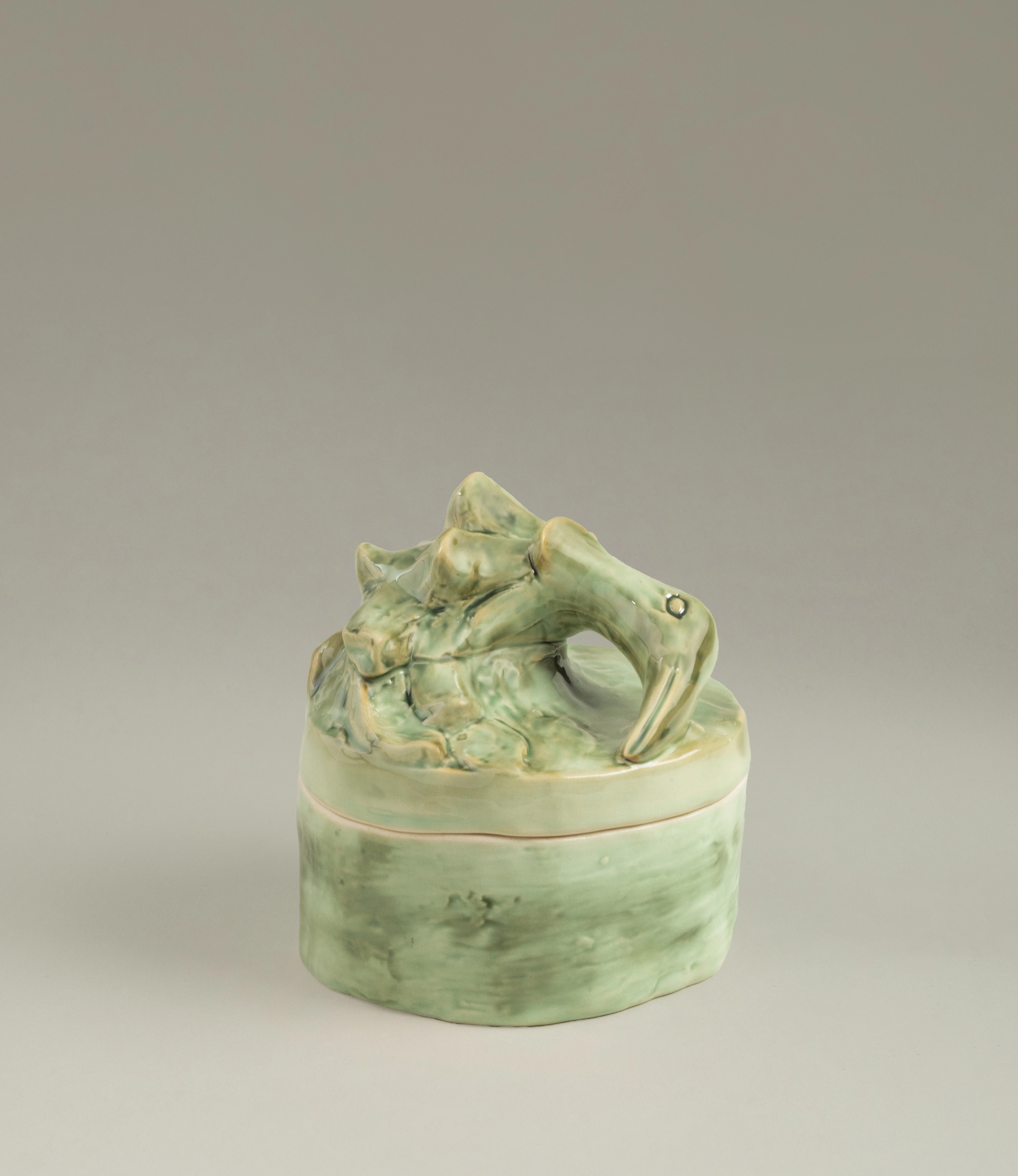 Serax Green Sonata medium-sized candle with a green ceramic container and an intricately sculpted lid featuring an abstract animal-like form in matching green tones.