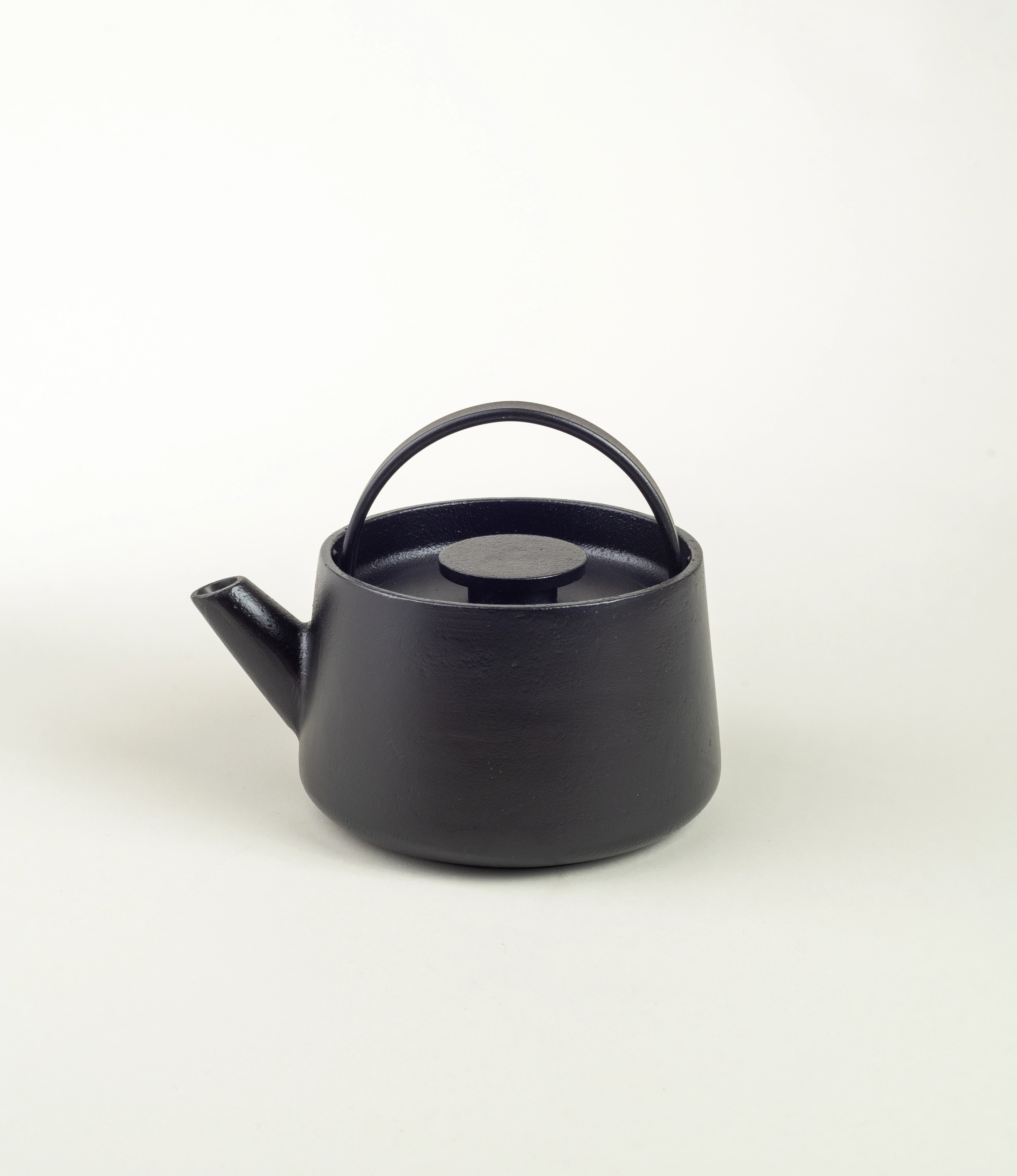 Inku Tea Pot from Serax is a black cast iron item. The shape is simple and functional. There is a steel strainer inside which closes with the cast iron lid. The handle is on the top of the product.