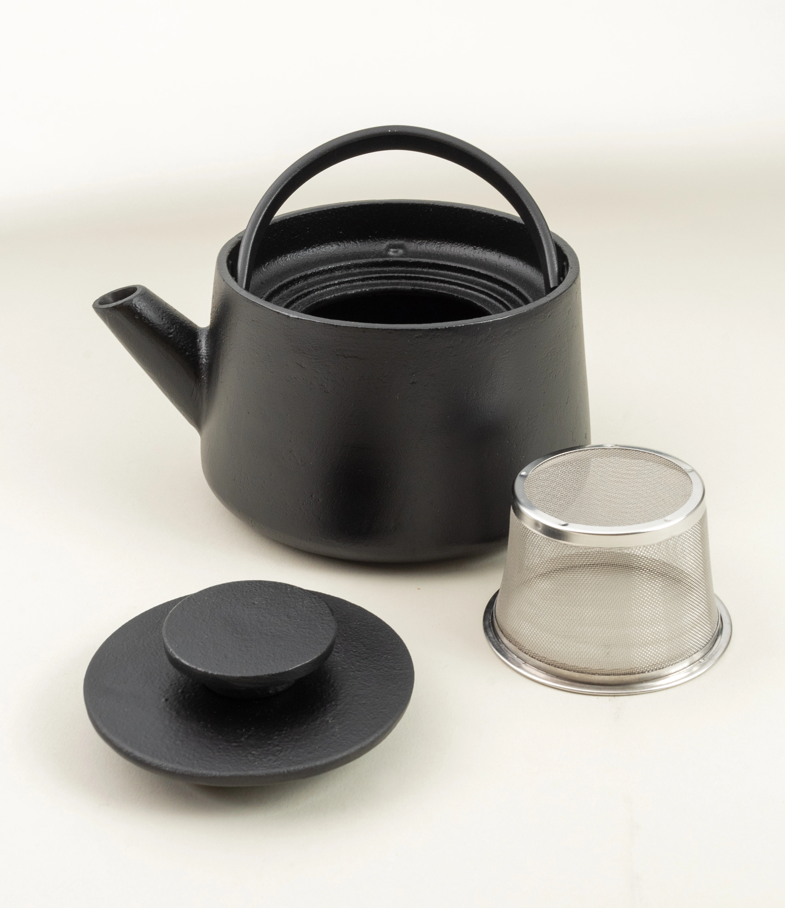 Inku Tea Pot from Serax is a black cast iron item. The shape is simple and functional. There is a steel strainer inside which closes with the cast iron lid. The handle is on the top of the product.