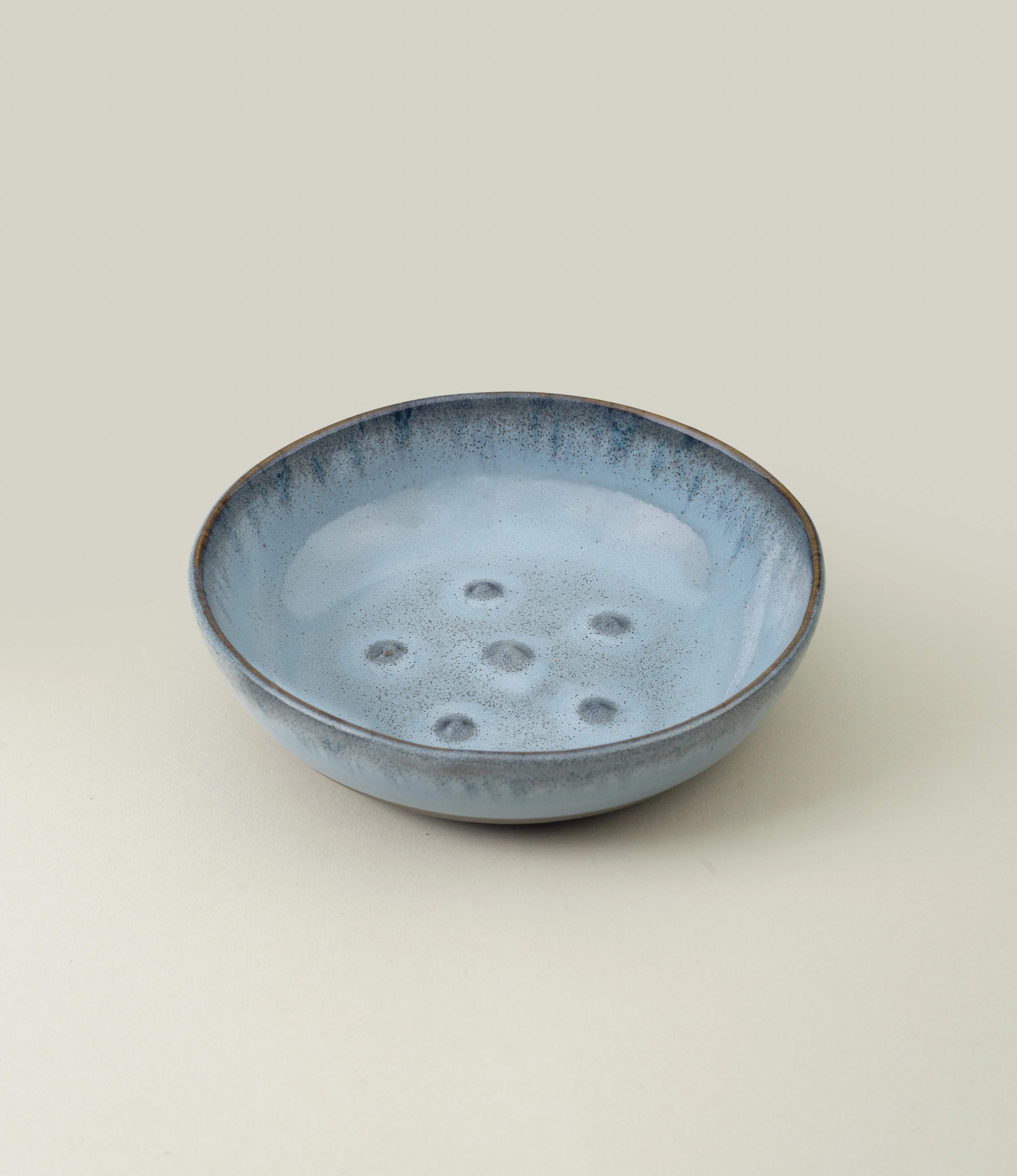 Blue Soap dish from Serax. The round item is made of ceramics and have a blue glazing with a grey unglazed matt area on the bottom. On the edges it has a grey rim.
