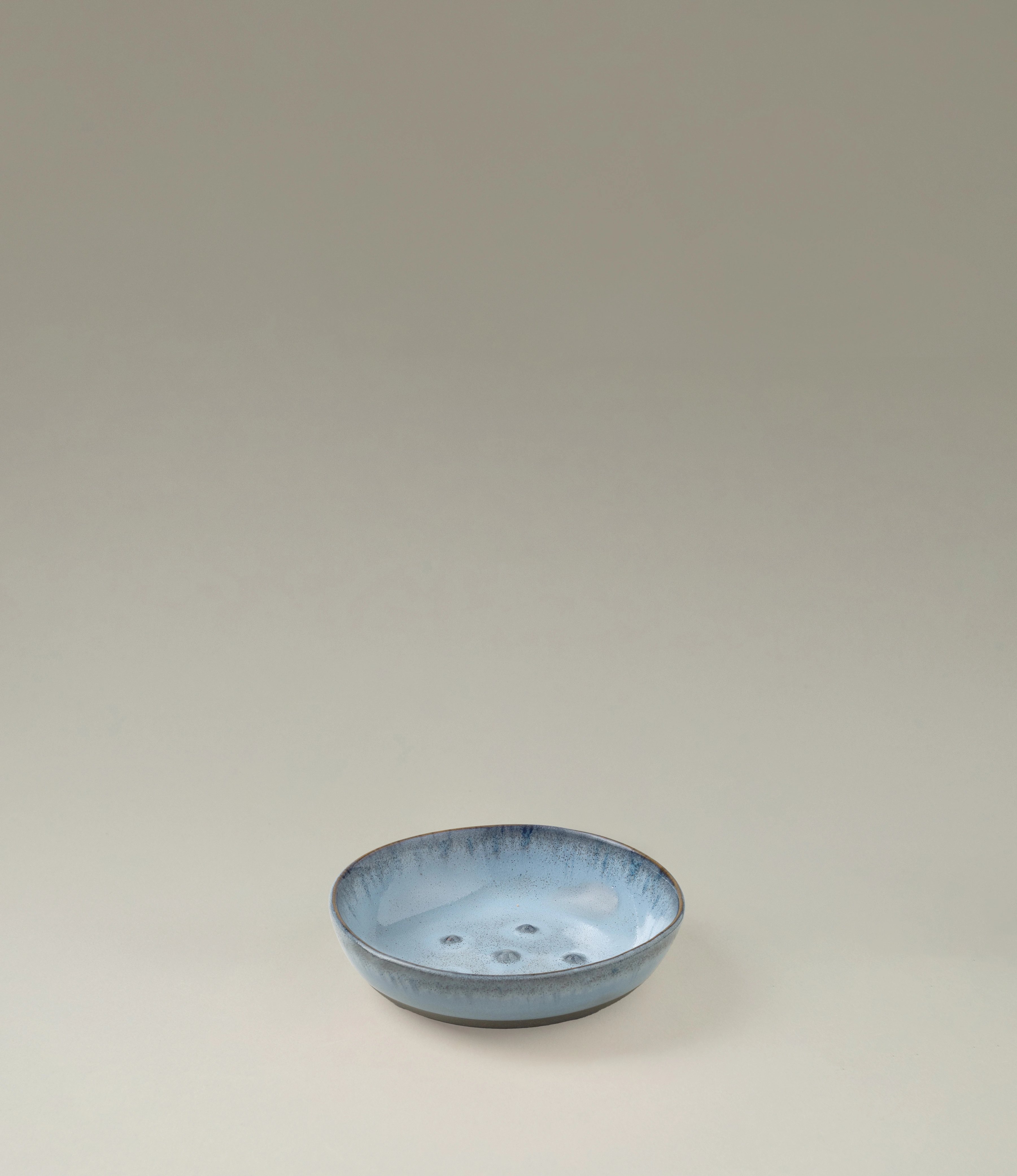 Blue Soap dish from Serax. The round item is made of ceramics and have a blue glazing with a grey unglazed matt area on the bottom. On the edges it has a grey rim.