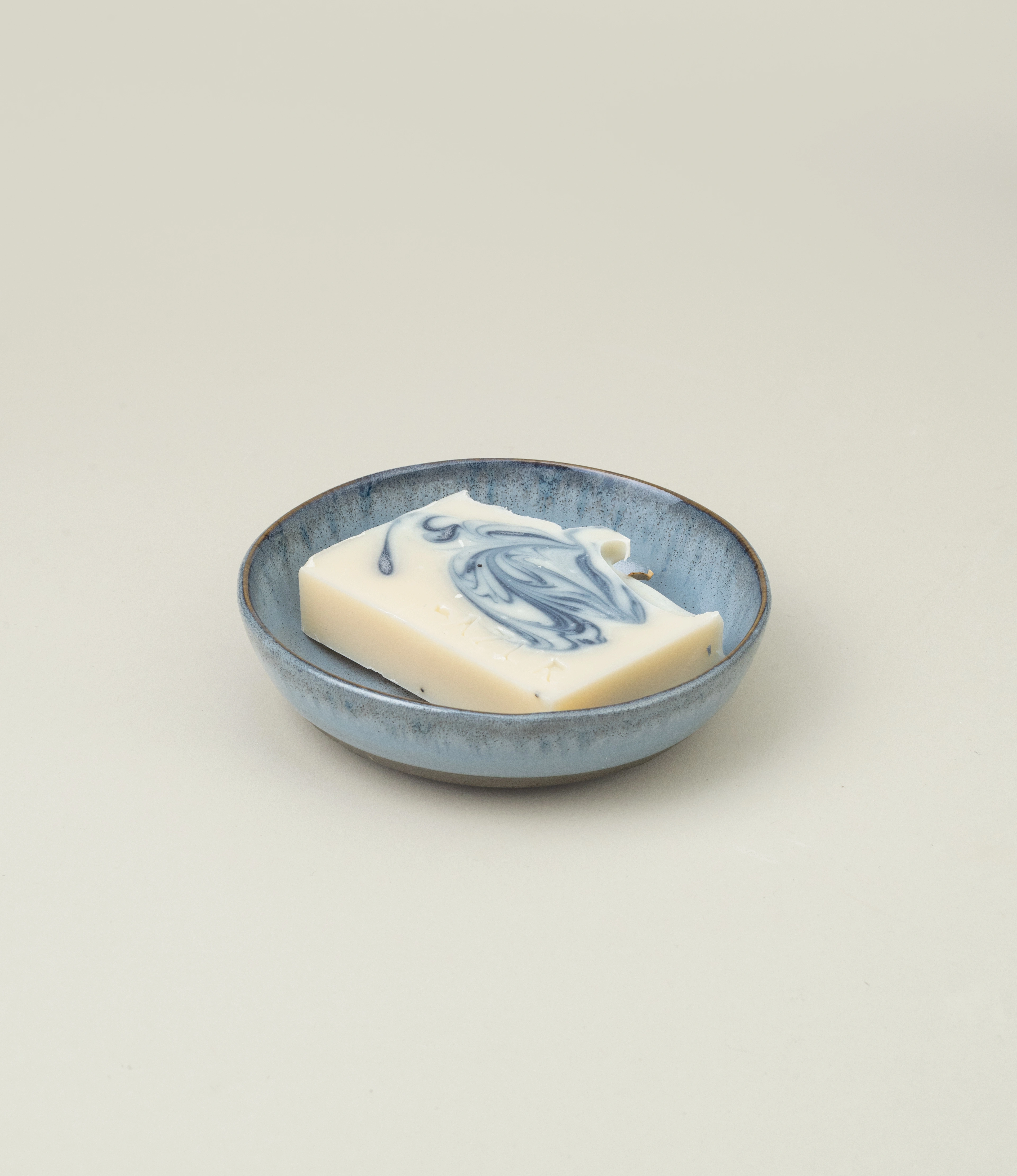 Serax Blue Soap Dish featuring a soft blue glaze with a rustic finish, paired with a beautifully swirled soap bar. A perfect blend of functionality and artistic elegance for your bathroom decor.