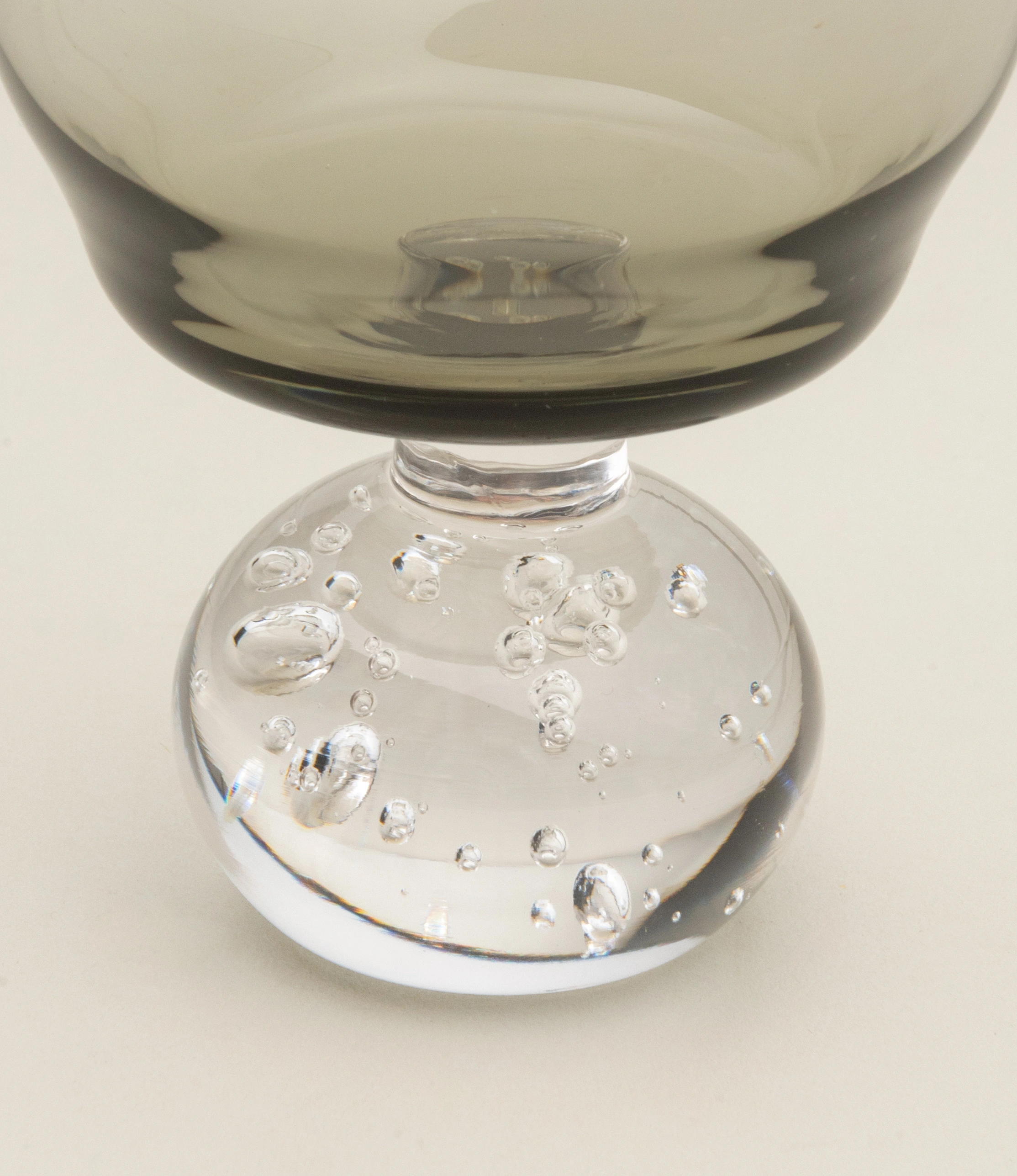 Close-up of the Serax Stem Glass, showcasing the textured spherical base with intricate air bubble details, paired with a smoky-tinted bowl for a sophisticated look.