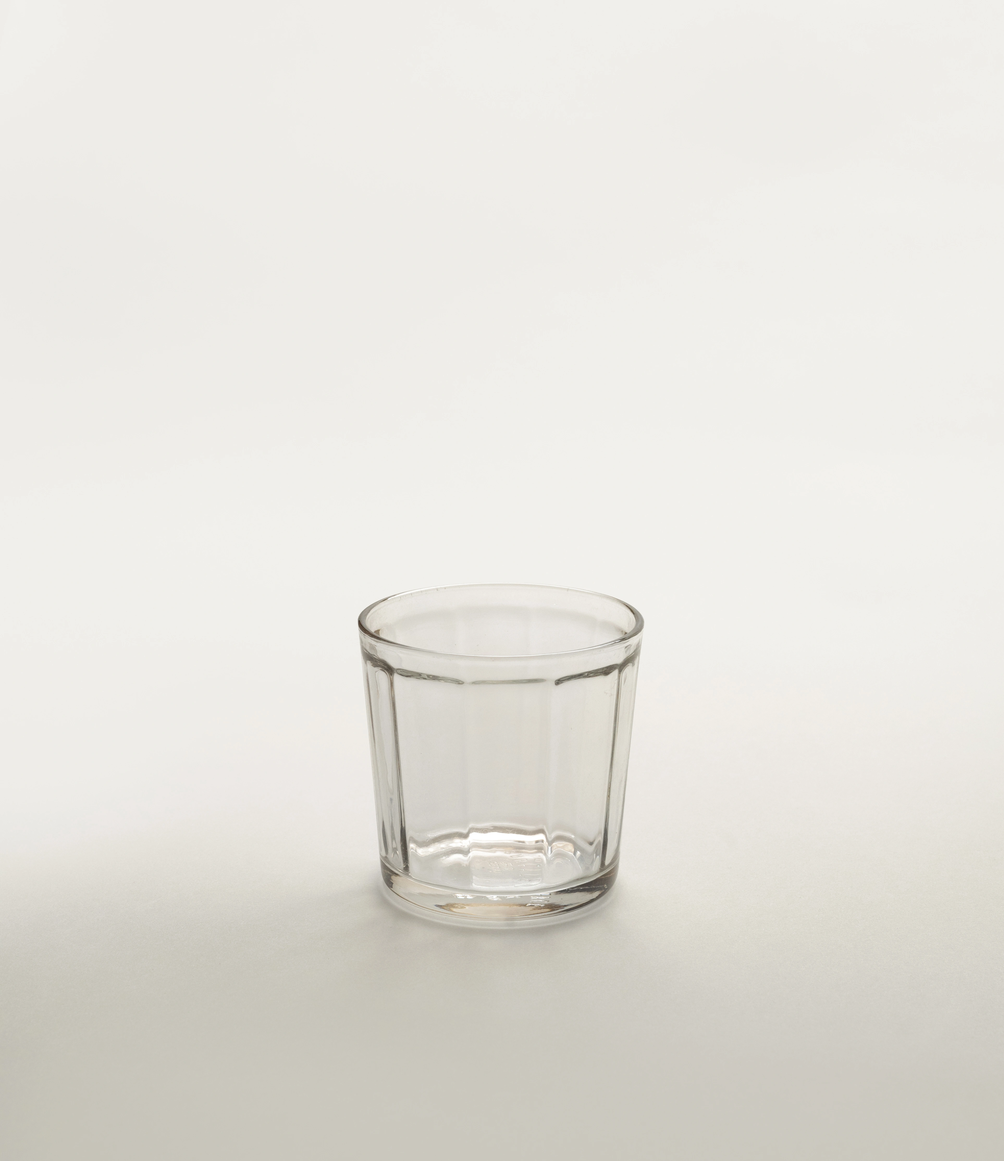 A single clear glass tumbler by Serax, featuring a fluted design, displayed on a light neutral background.