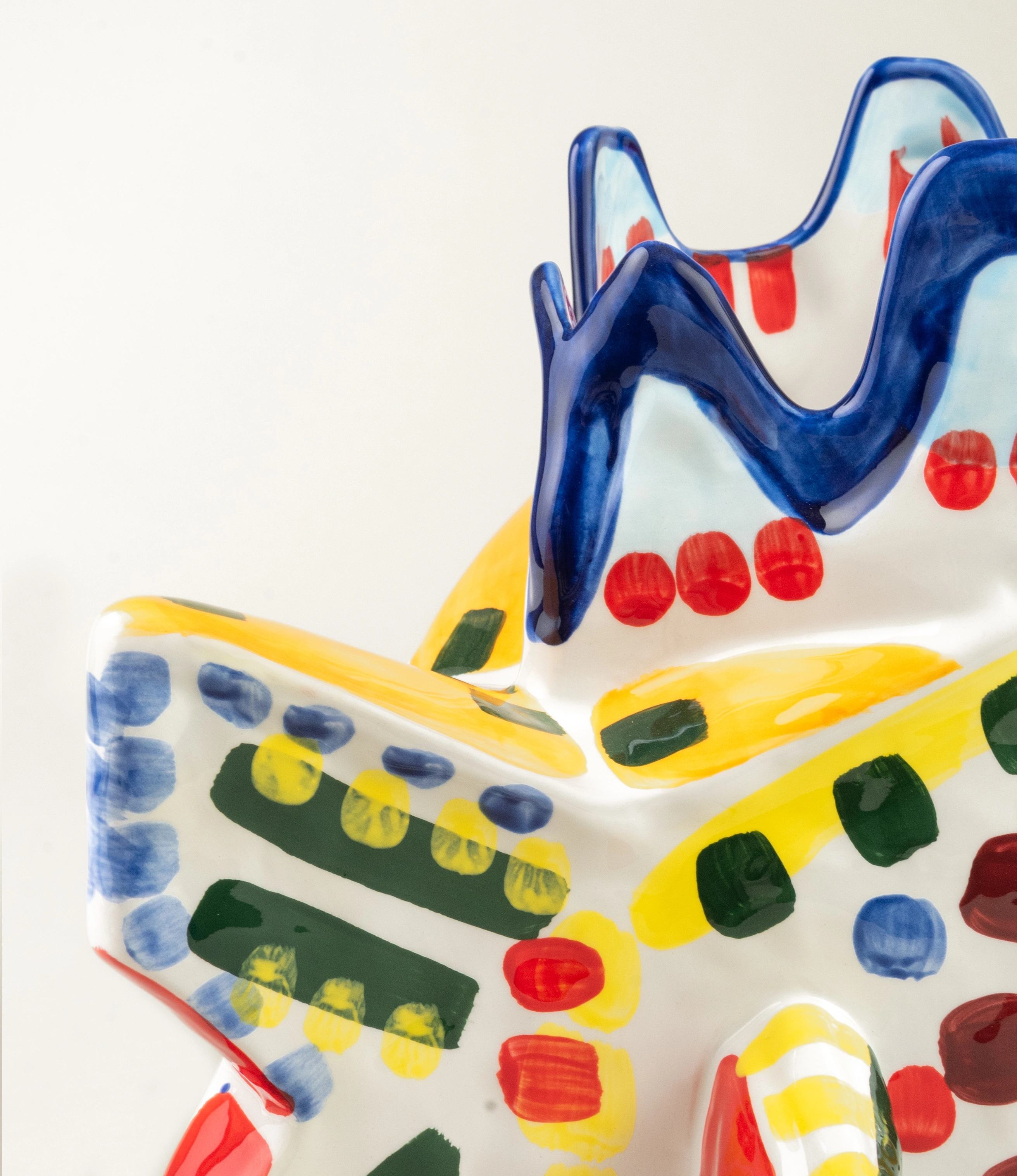 Sicily Fish is a handmade ceramic vase. The item is handpainted in a colorful green, blue, yellow and red pattern. The bold product is designed by Bisignano.