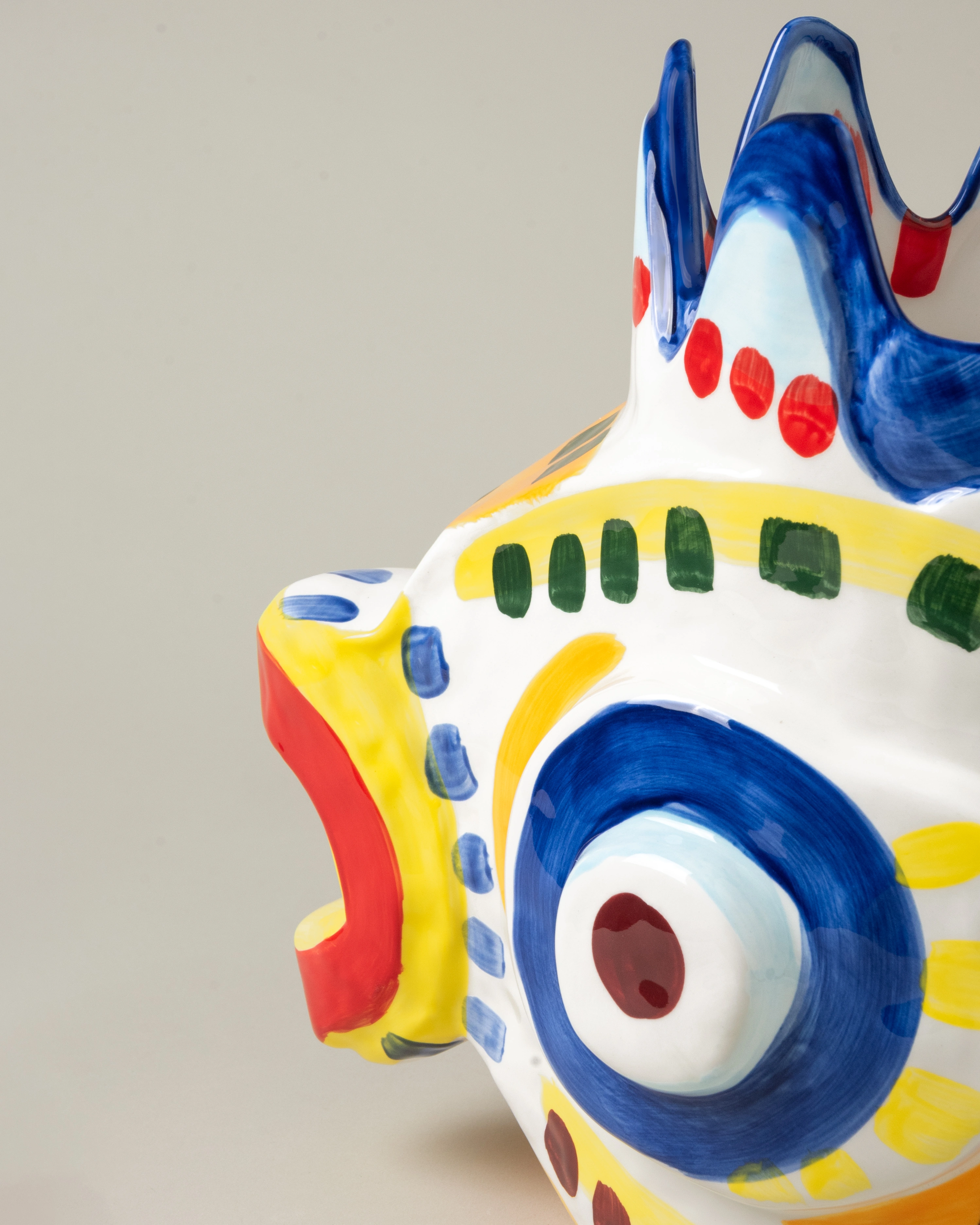 Sicily Fish is a handmade ceramic vase. The item is handpainted in a colorful green, blue, yellow and red pattern. The bold product is designed by Bisignano.