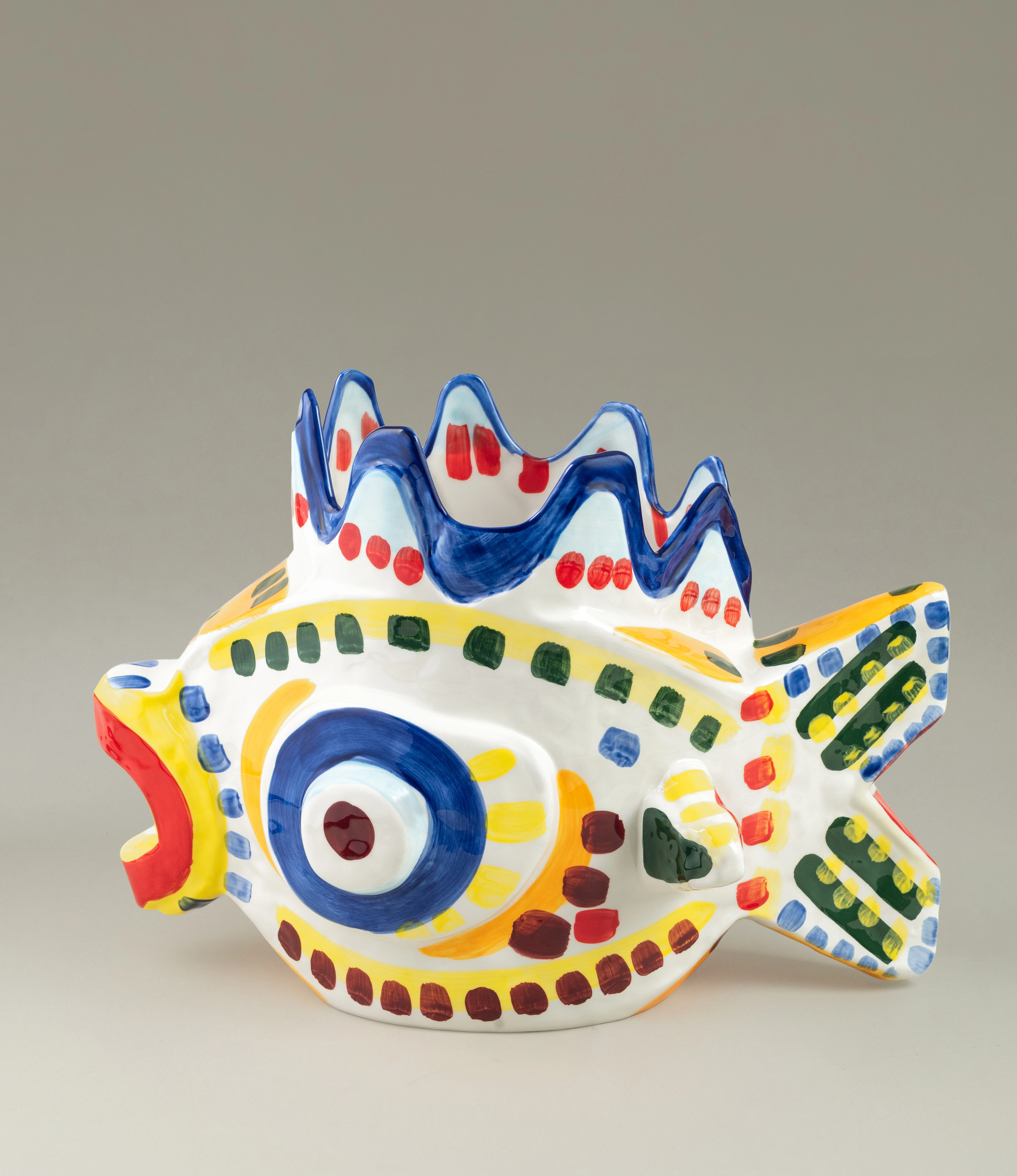A vibrant ceramic vase in the shape of a fish, adorned with colorful hand-painted patterns inspired by Sicilian artistry. Perfect as a statement piece for adding a playful touch to your decor.