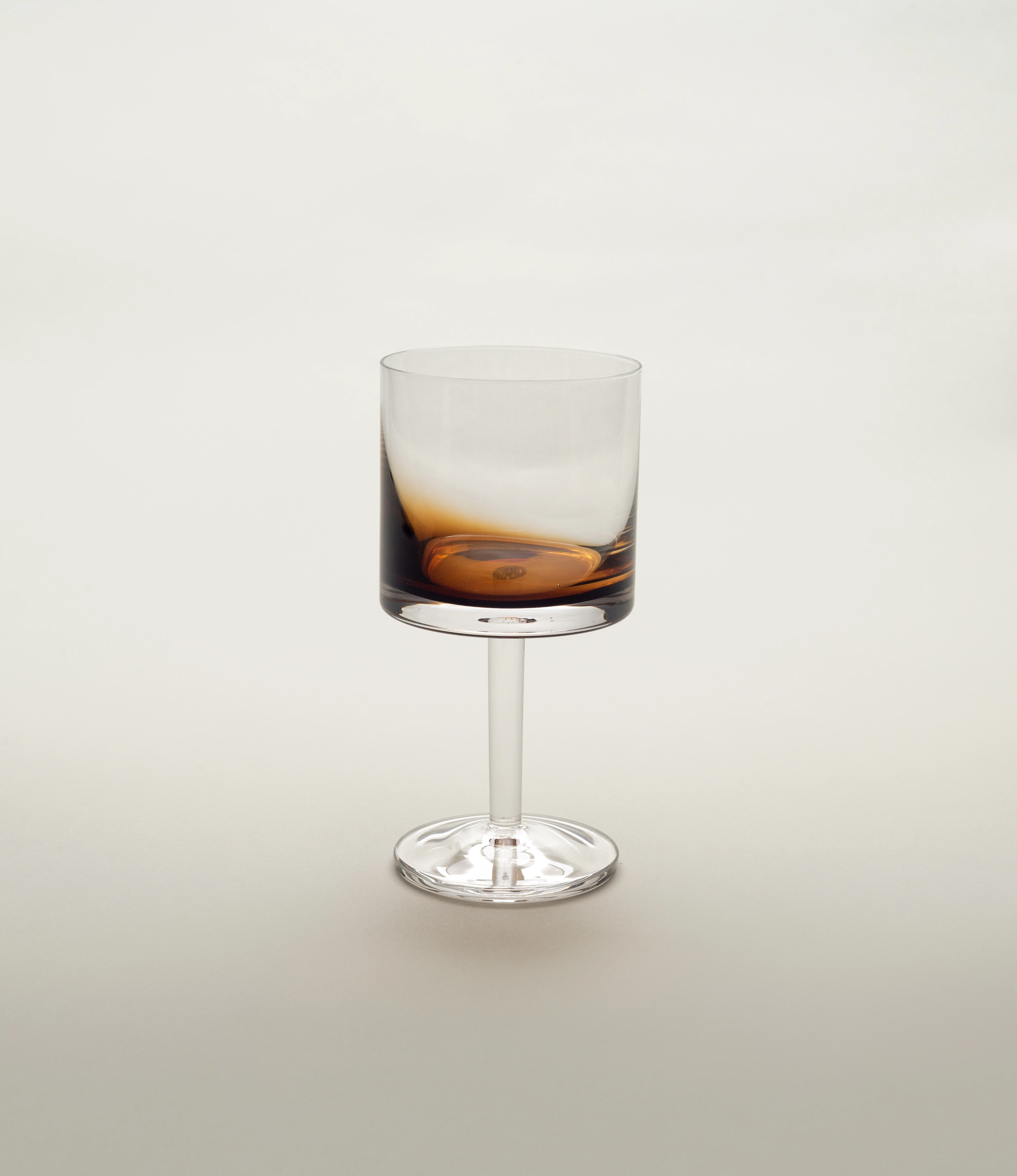 A stylish Serax red wine glass from the Zuma collection, featuring a contemporary design with a smooth cylindrical bowl and a sleek stem, set against a light neutral background.