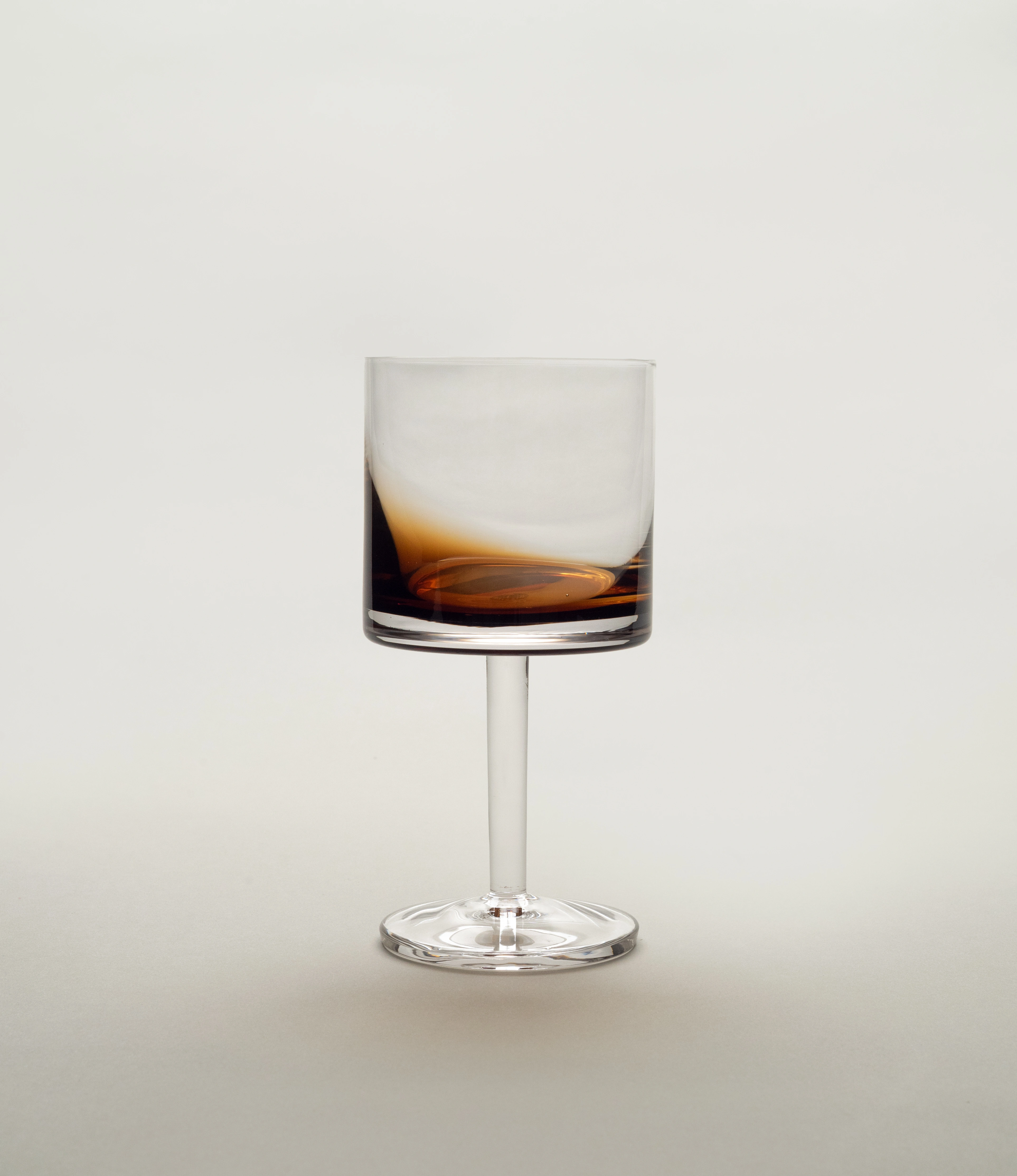 A stylish Serax red wine glass from the Zuma collection, featuring a contemporary design with a smooth cylindrical bowl and a sleek stem, set against a light neutral background.
