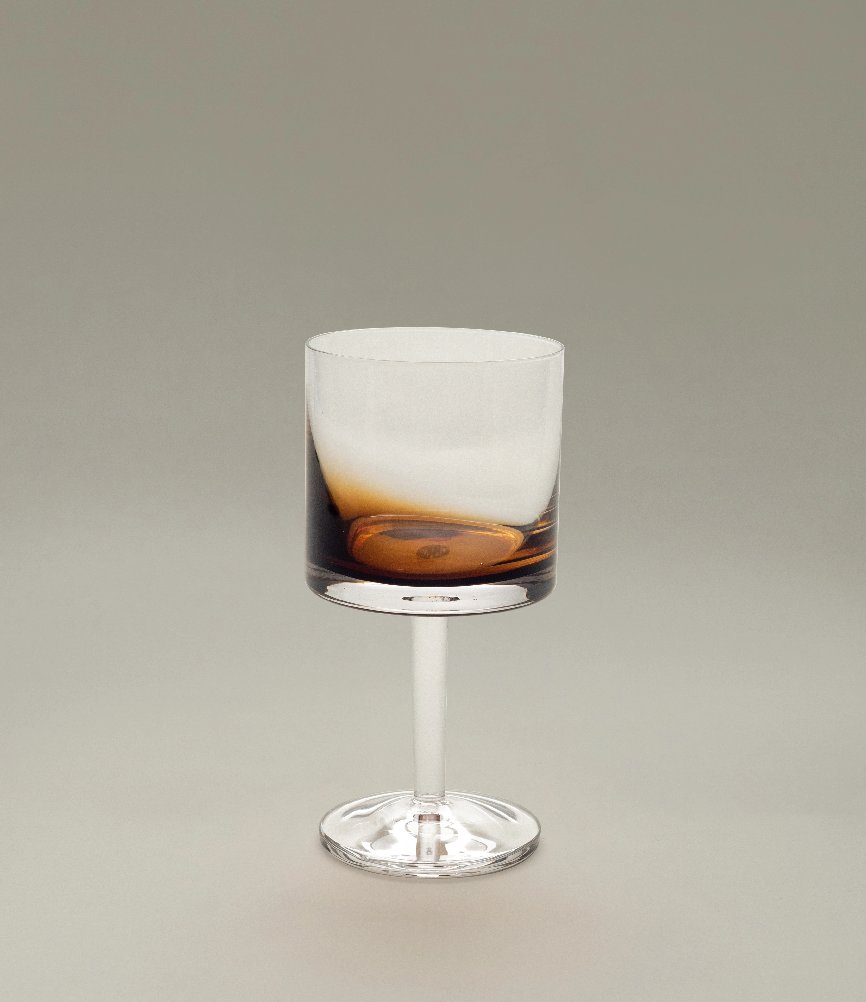 A stylish Serax red wine glass from the Zuma collection, featuring a contemporary design with a smooth cylindrical bowl and a sleek stem, set against a light neutral background.