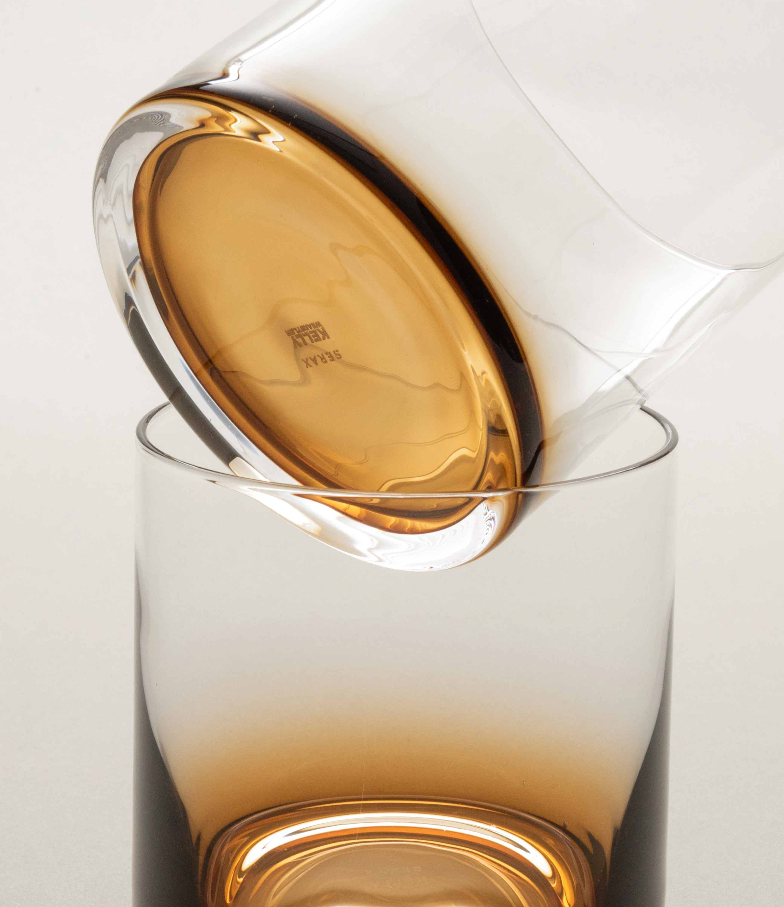 Close-up of Serax Zuma whiskey glass showcasing its amber gradient and intricate craftsmanship, highlighting the base details and modern curvature.