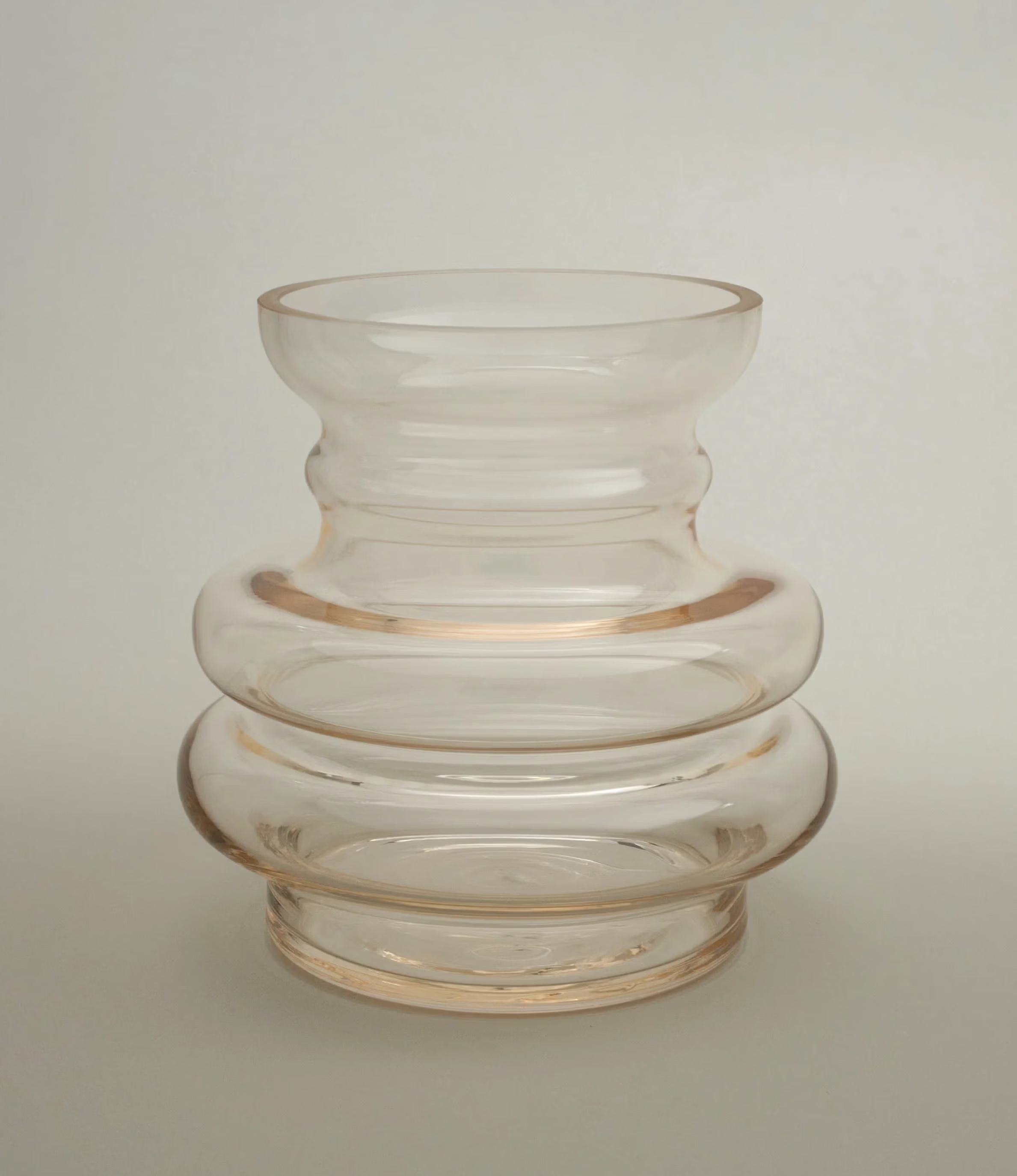 Curve Vase Gul from Stences is a glass vase which has a hint of beige color on it. Still very transparent and glossy.