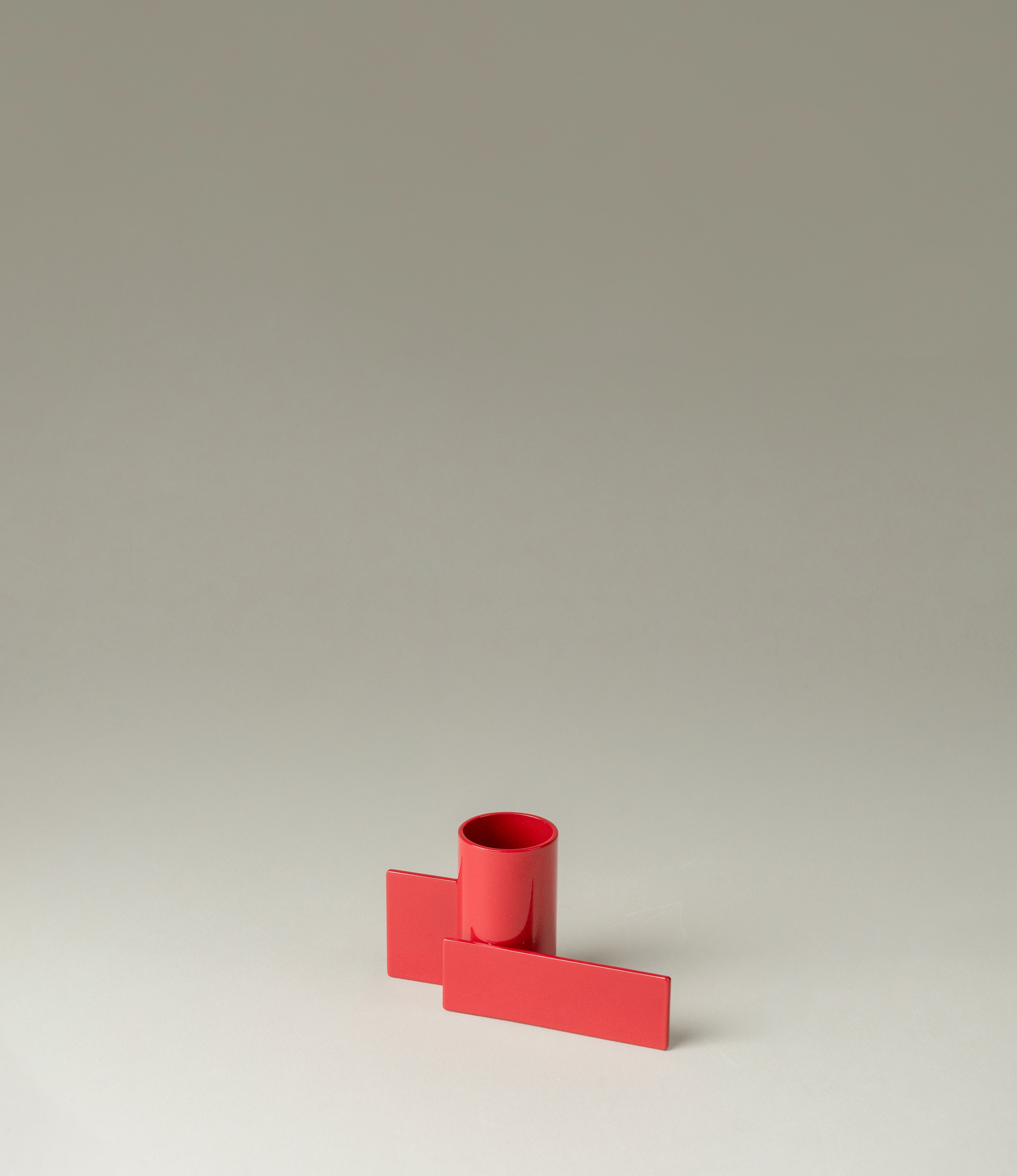 Icon Iysestage 01 from Stences is a candleholder made for taper candles. This picture shows the red variant of this item. The steel material has a glossy surface which emphasize the soft geometric shapes of the product in question.
