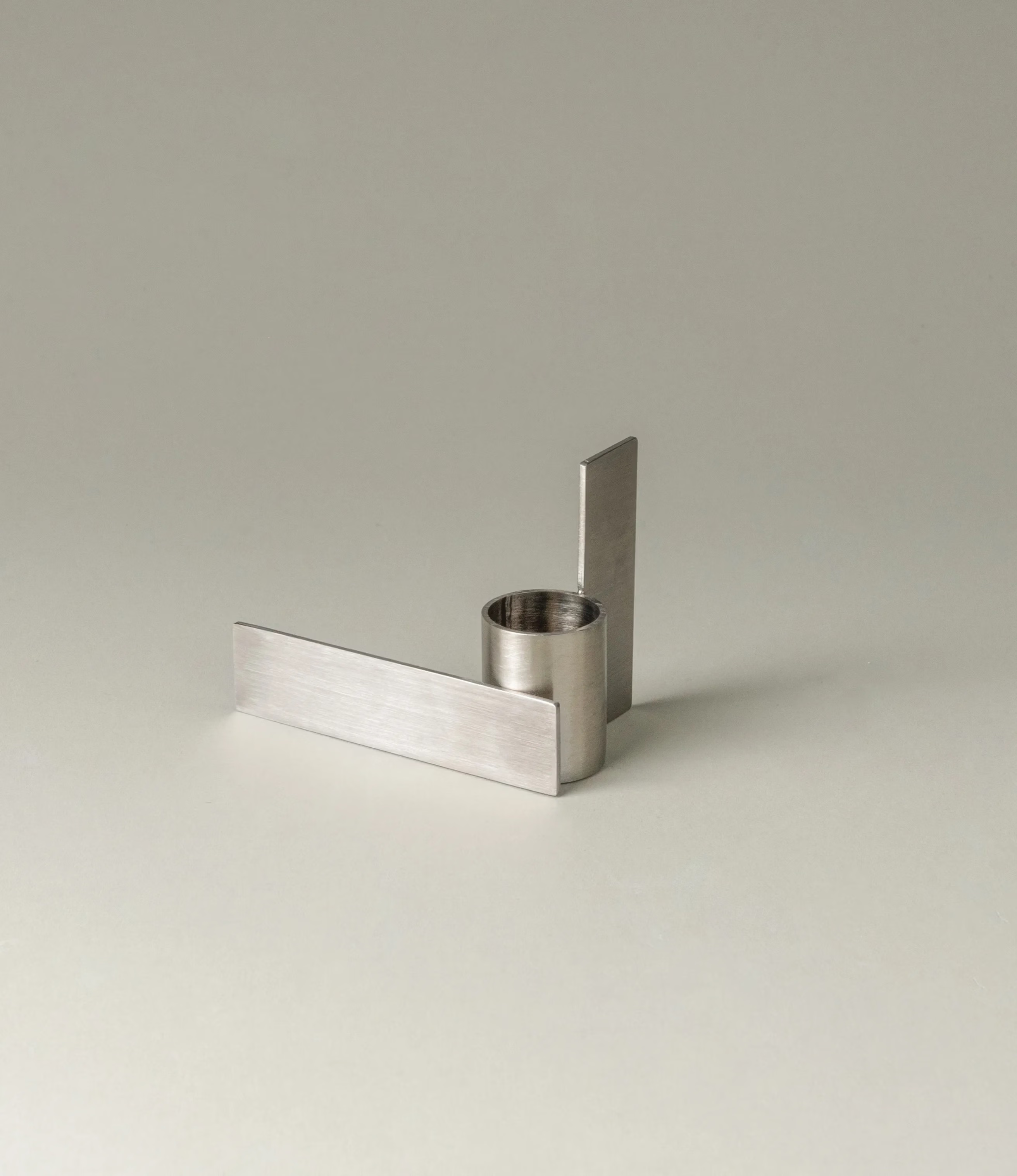 Icon Iysestage 02 from Stences is a candleholder made for taper candles. This picture shows the chrome variant of this item. The steel material has a brushed surface which emphasize the soft geometric shapes of the product in question. Perfect fit for your brutalist, minimalist home.