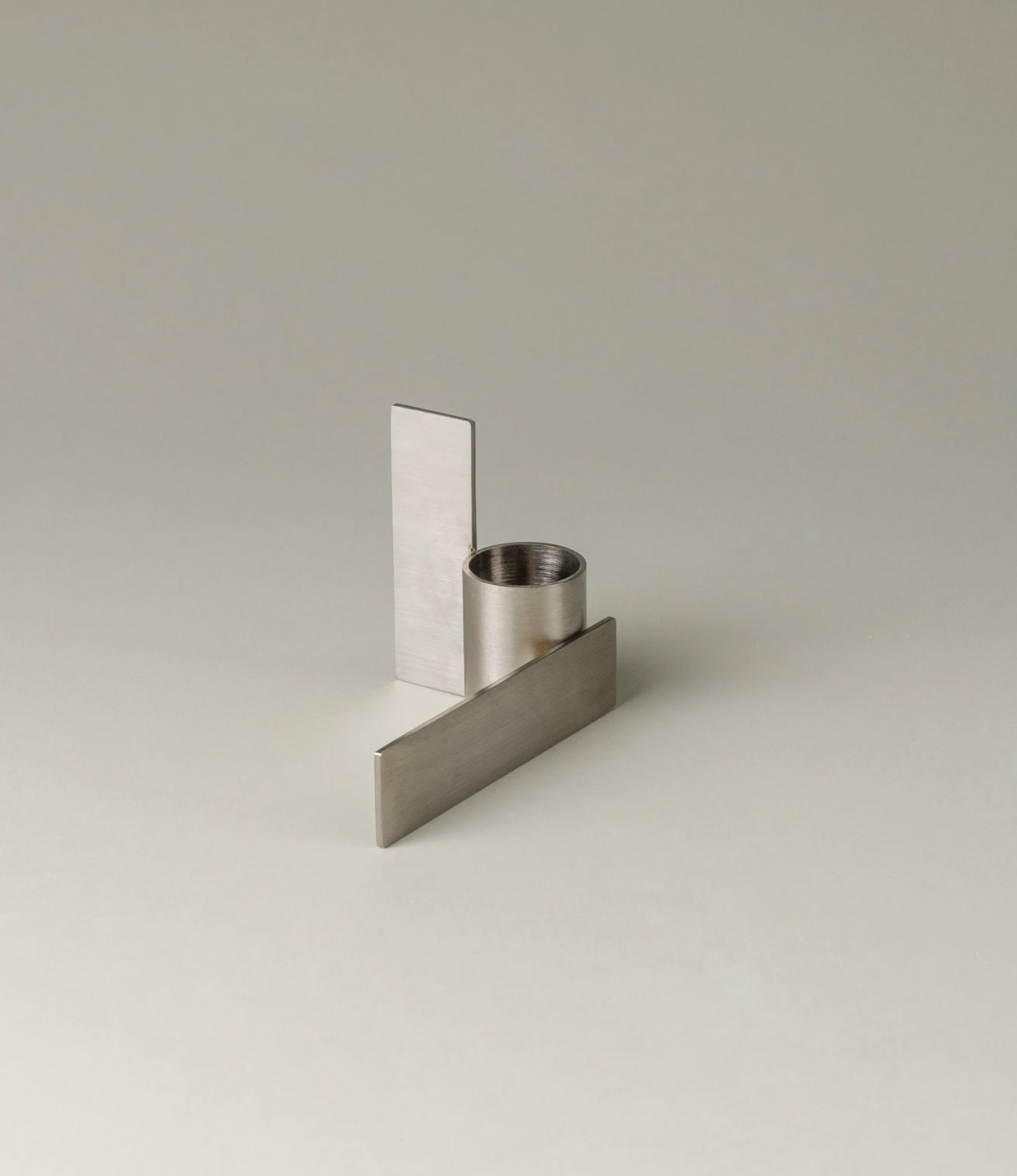 Icon Iysestage 02 from Stences is a candleholder made for taper candles. This picture shows the chrome variant of this item. The steel material has a brushed surface which emphasize the soft geometric shapes of the product in question. Perfect fit for your brutalist, minimalist home.