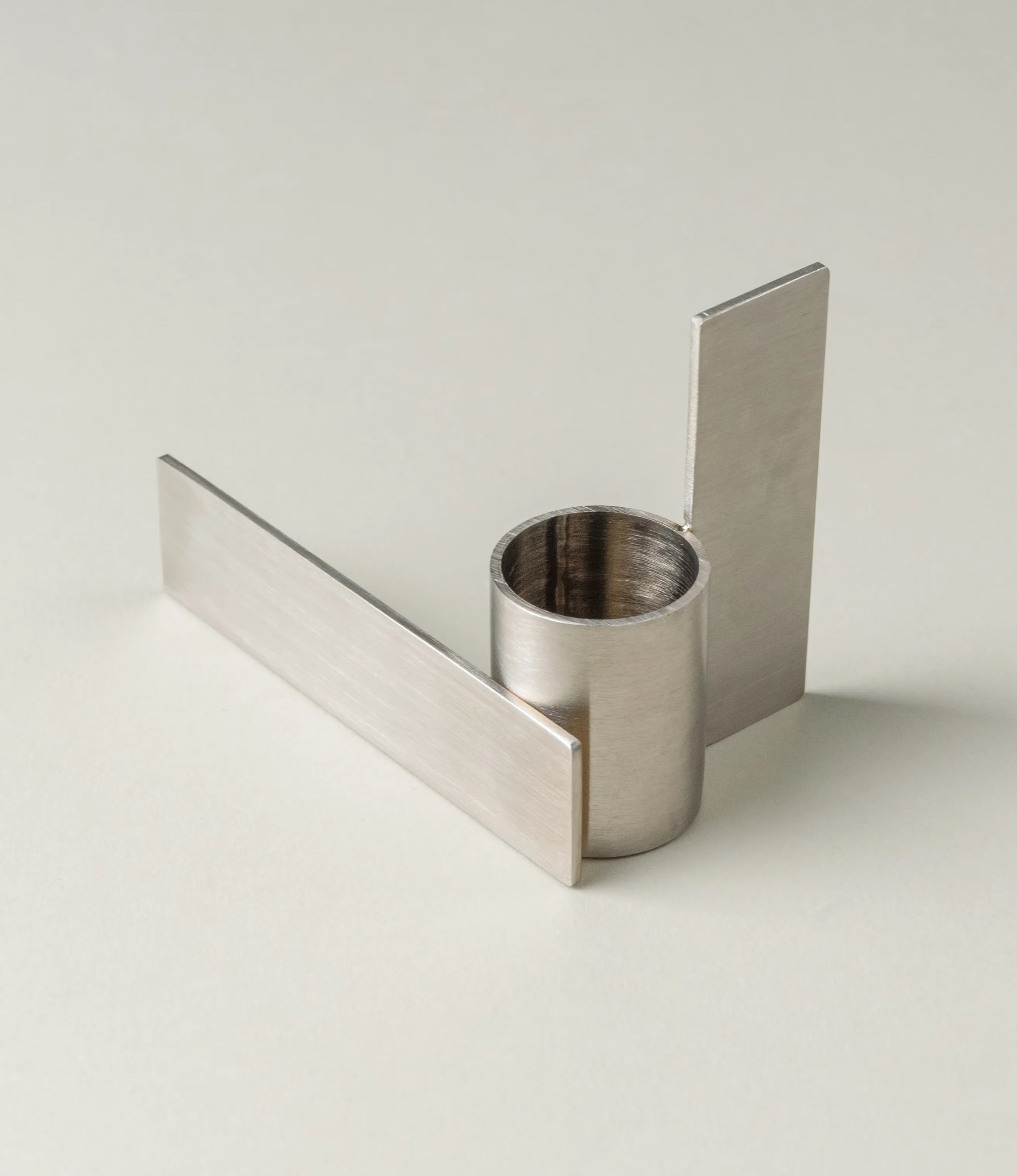 Icon Iysestage 02 from Stences is a candleholder made for taper candles. This picture shows the chrome variant of this item. The steel material has a brushed surface which emphasize the soft geometric shapes of the product in question. Perfect fit for your brutalist, minimalist home.