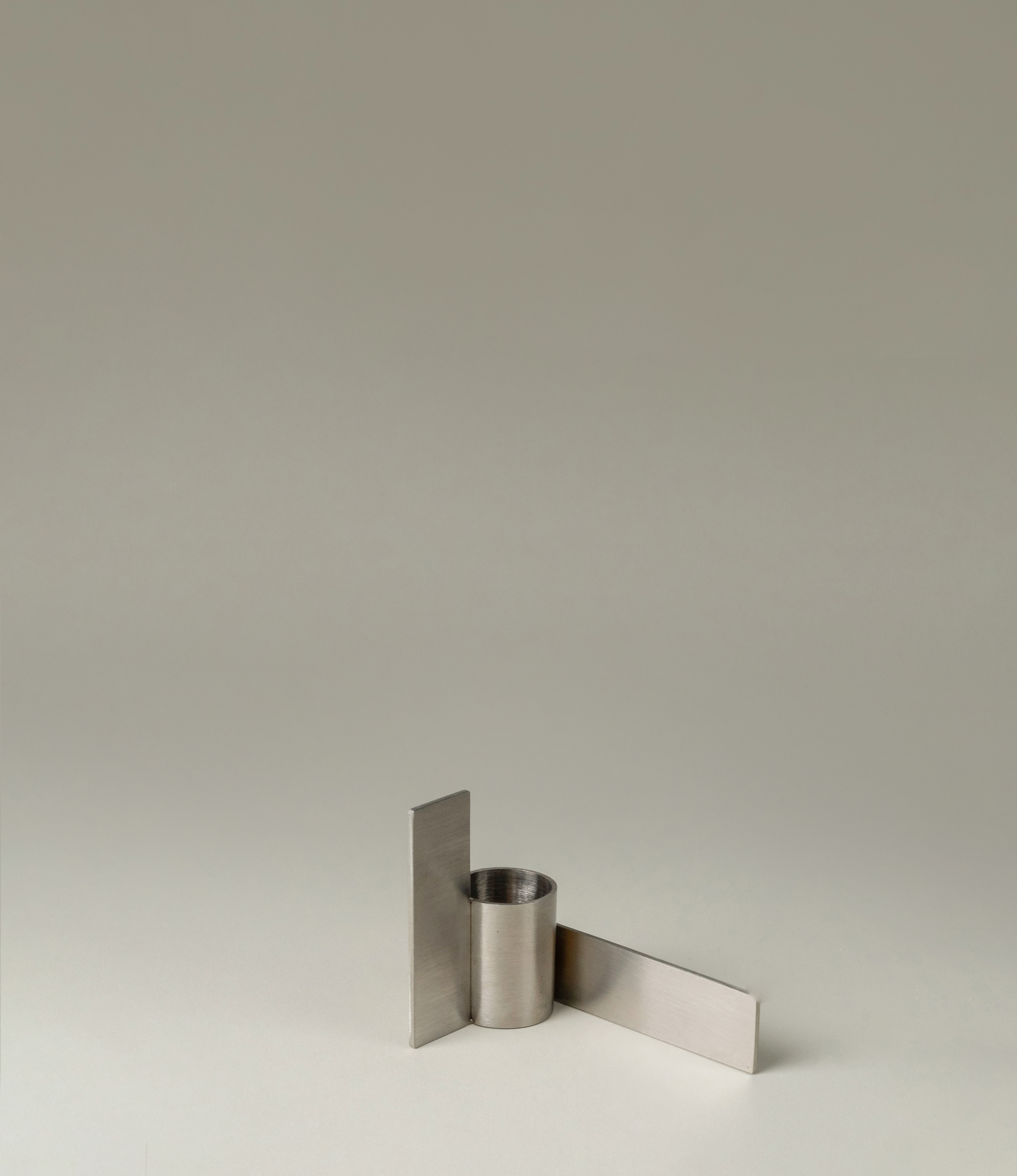 Icon Iysestage 02 from Stences is a candleholder made for taper candles. This picture shows the chrome variant of this item. The steel material has a brushed surface which emphasize the soft geometric shapes of the product in question. Perfect fit for your brutalist, minimalist home.