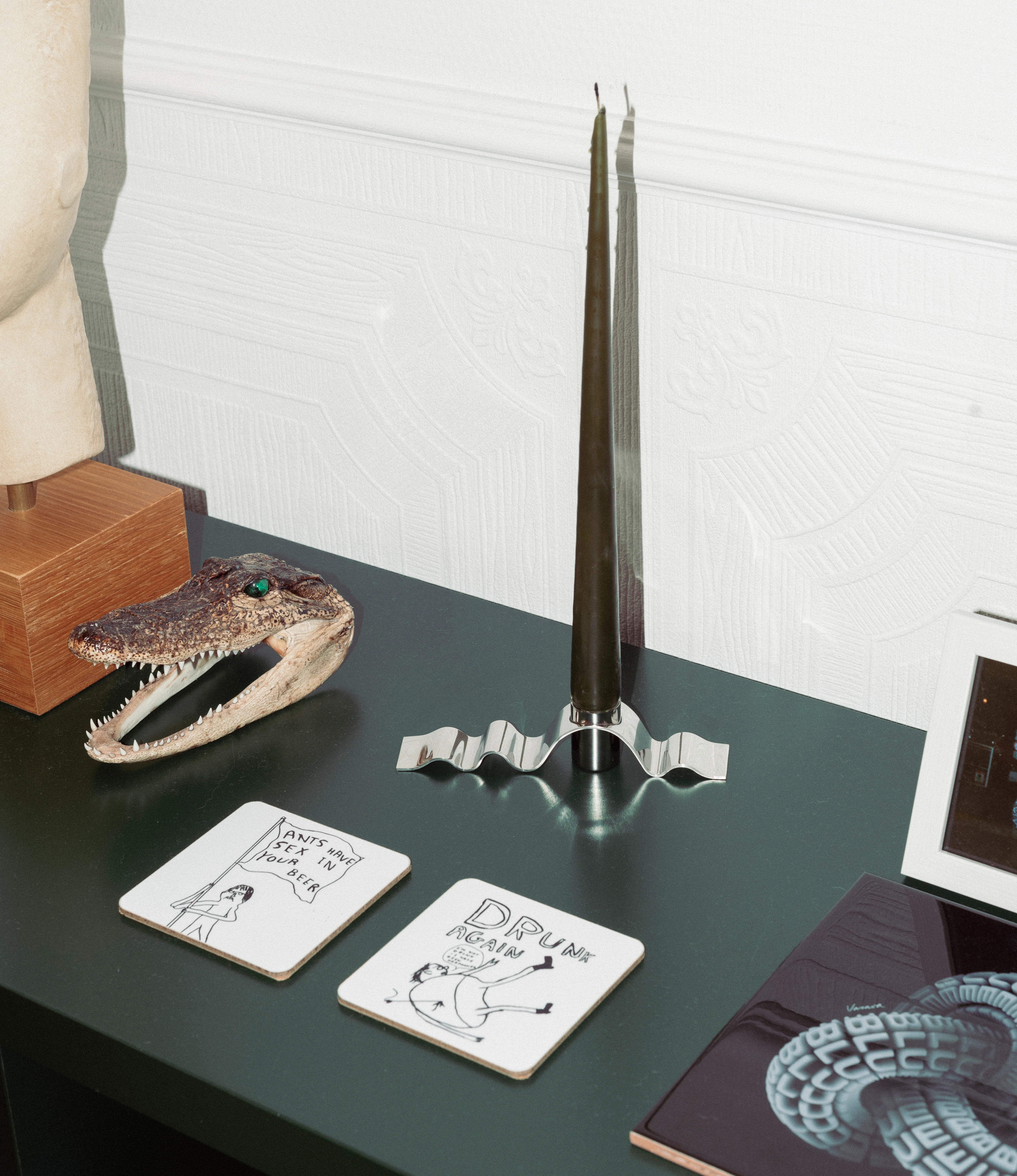 Stences Wave Candlestick holder in crome depicted in a beautiful interior and with a green candle inside