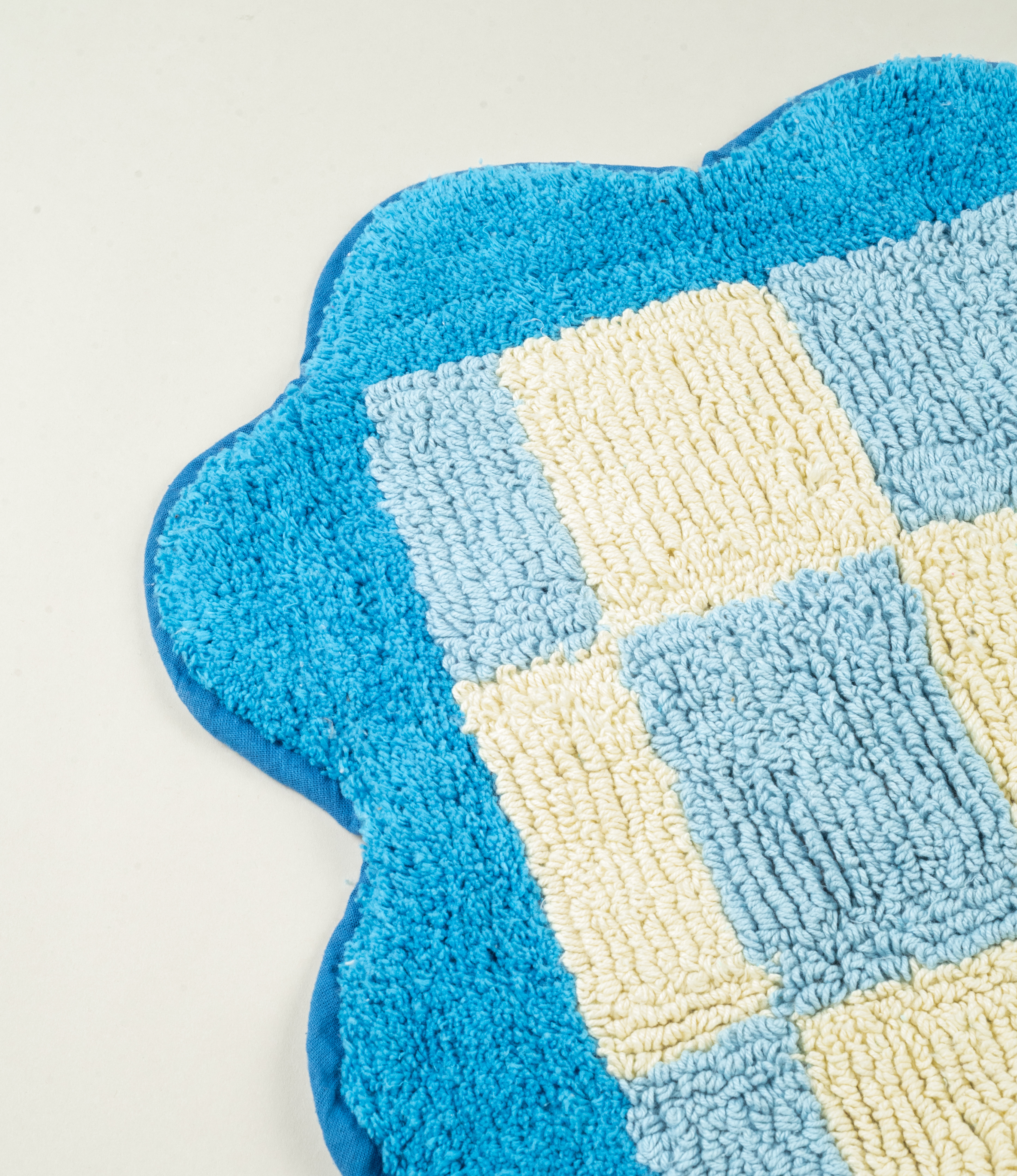 A close-up of Tarta Gelatina Burbuja Bathmat’s soft loops and scalloped edges, highlighting its craftsmanship and sustainable 100% cotton fabric.
