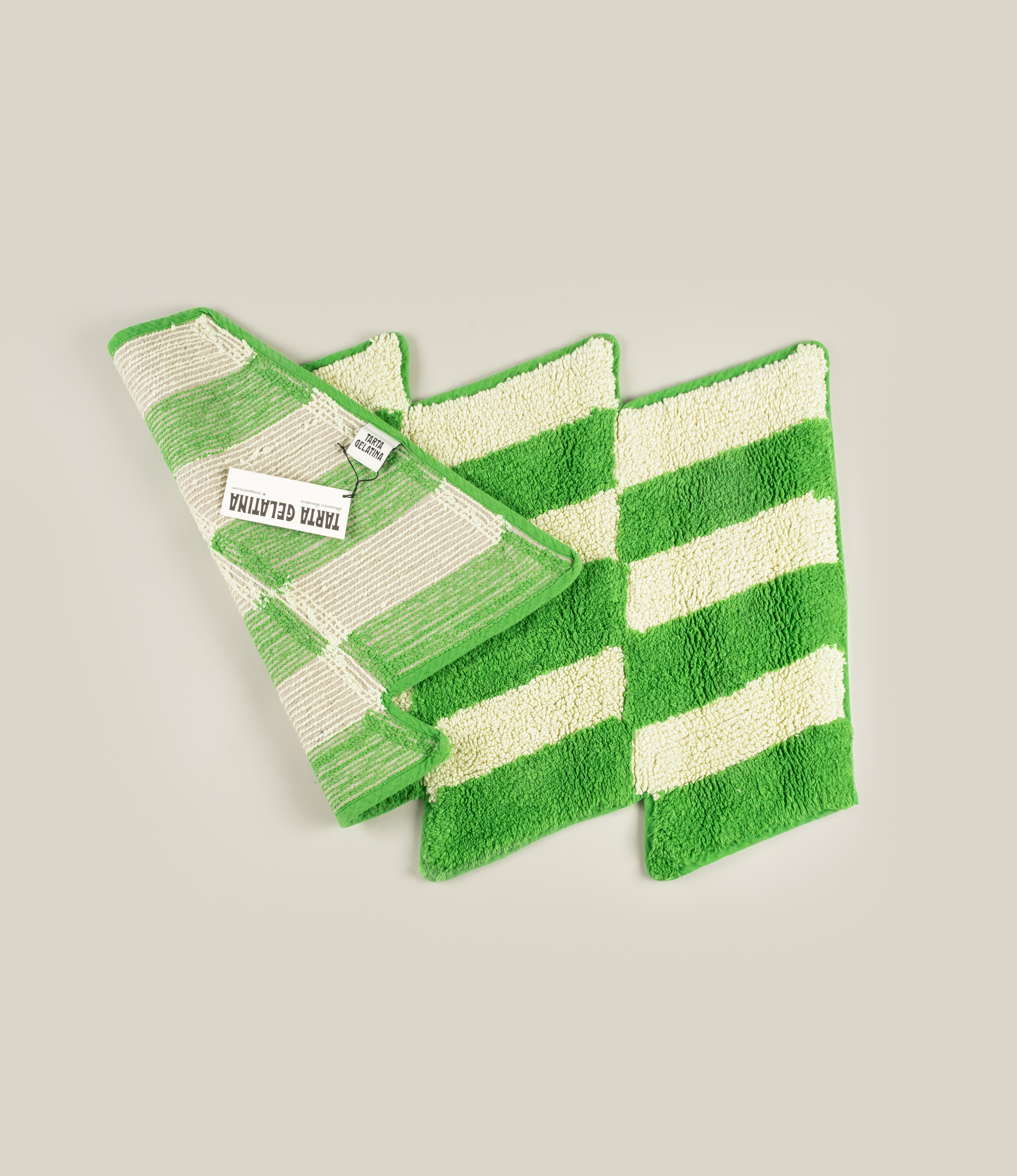 Reverse side of the Casette Bathmat by Tarta Gelatina, showcasing its woven cotton backing and the Tarta Gelatina brand label for authenticity and durability.
