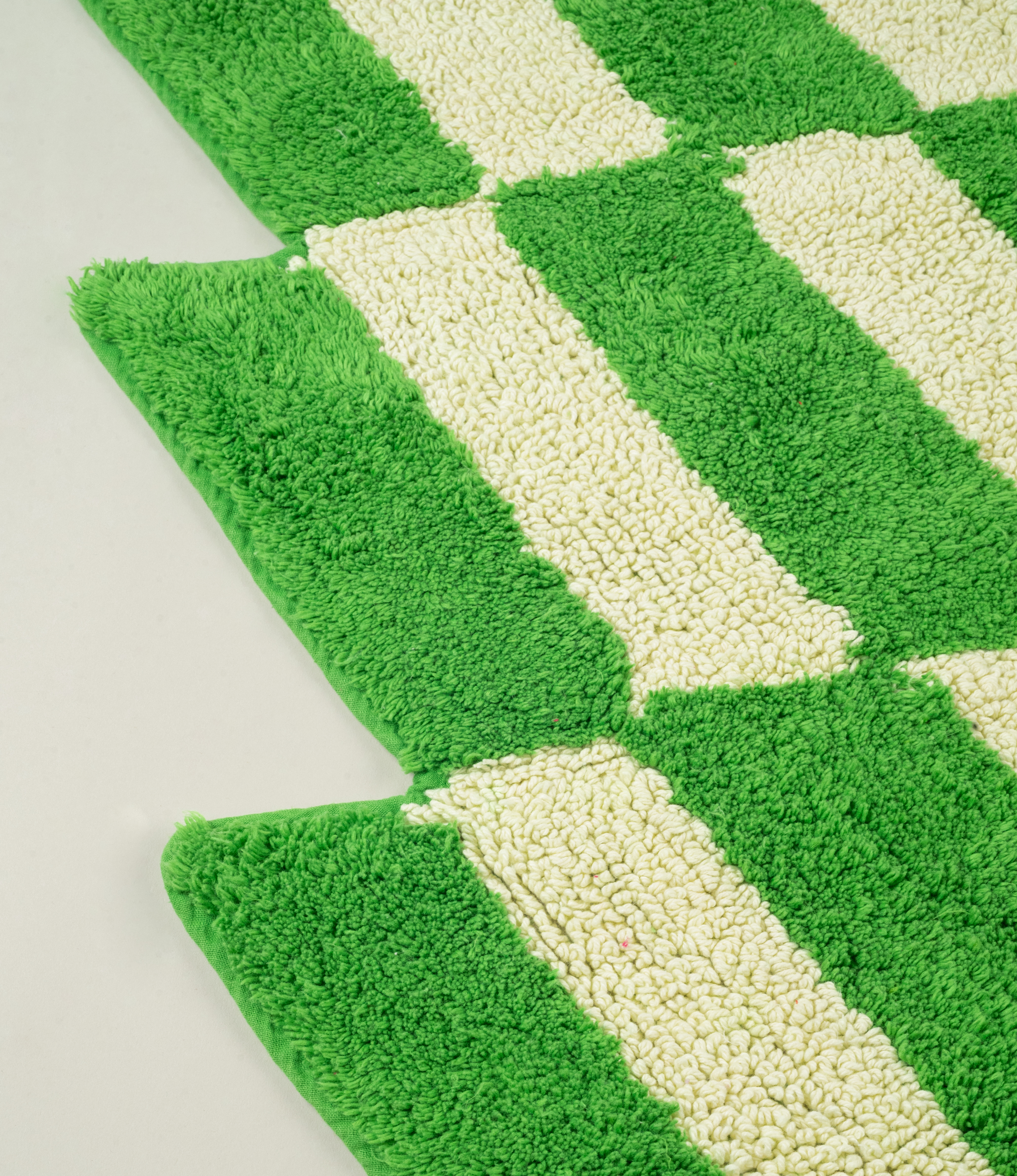 Detailed view of the Casette Bathmat’s by Tarta Gelatina plush cotton texture and crisp green and cream pattern, emphasizing its soft and absorbent surface.