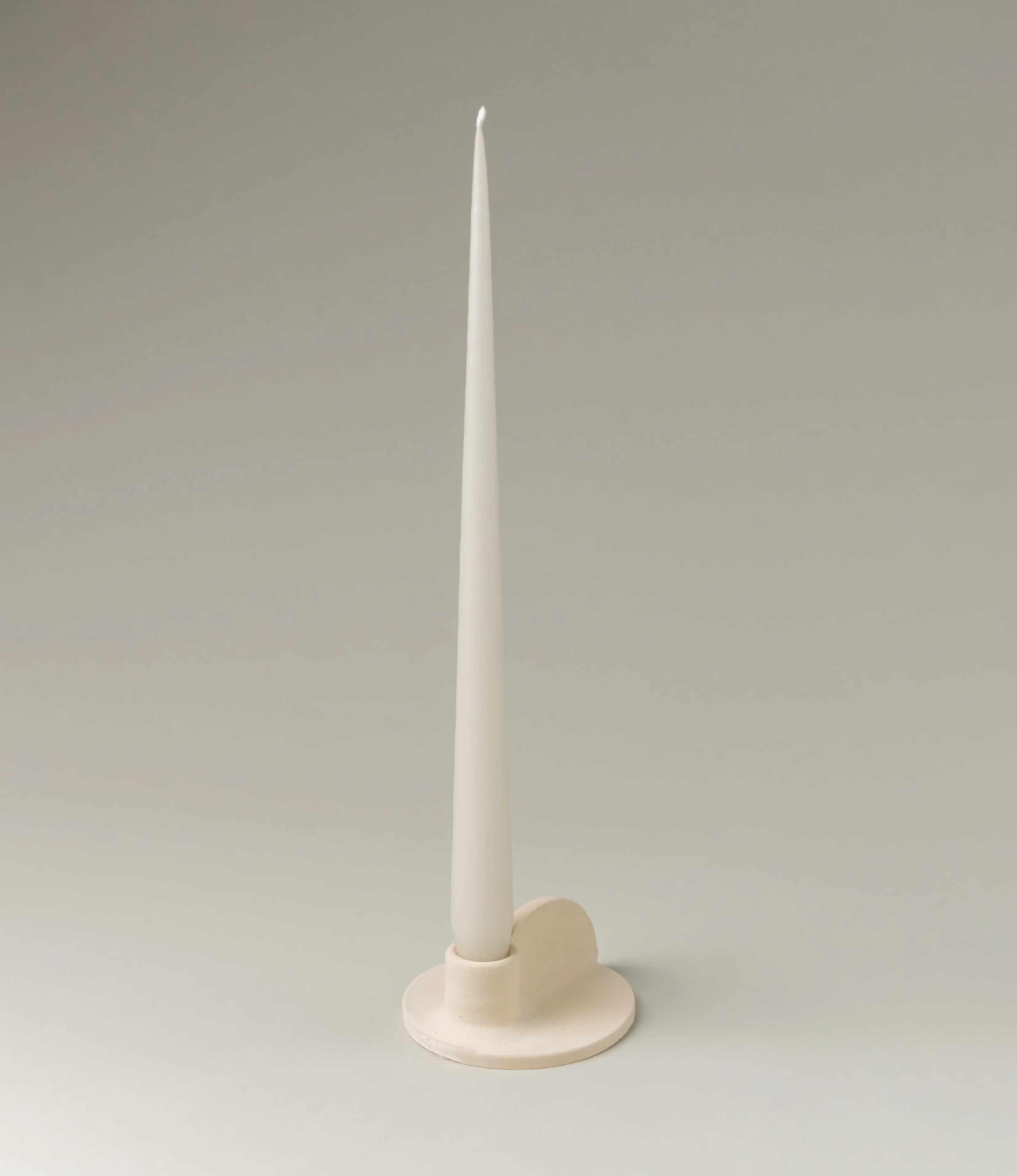 Myrtha Candle Holder is created by Alfareria La Nava. The product comes in a cream color and it has a natural matte finishing. In this picture you can see the product in use with the Ivory Taper Candle from Ester&Erik.