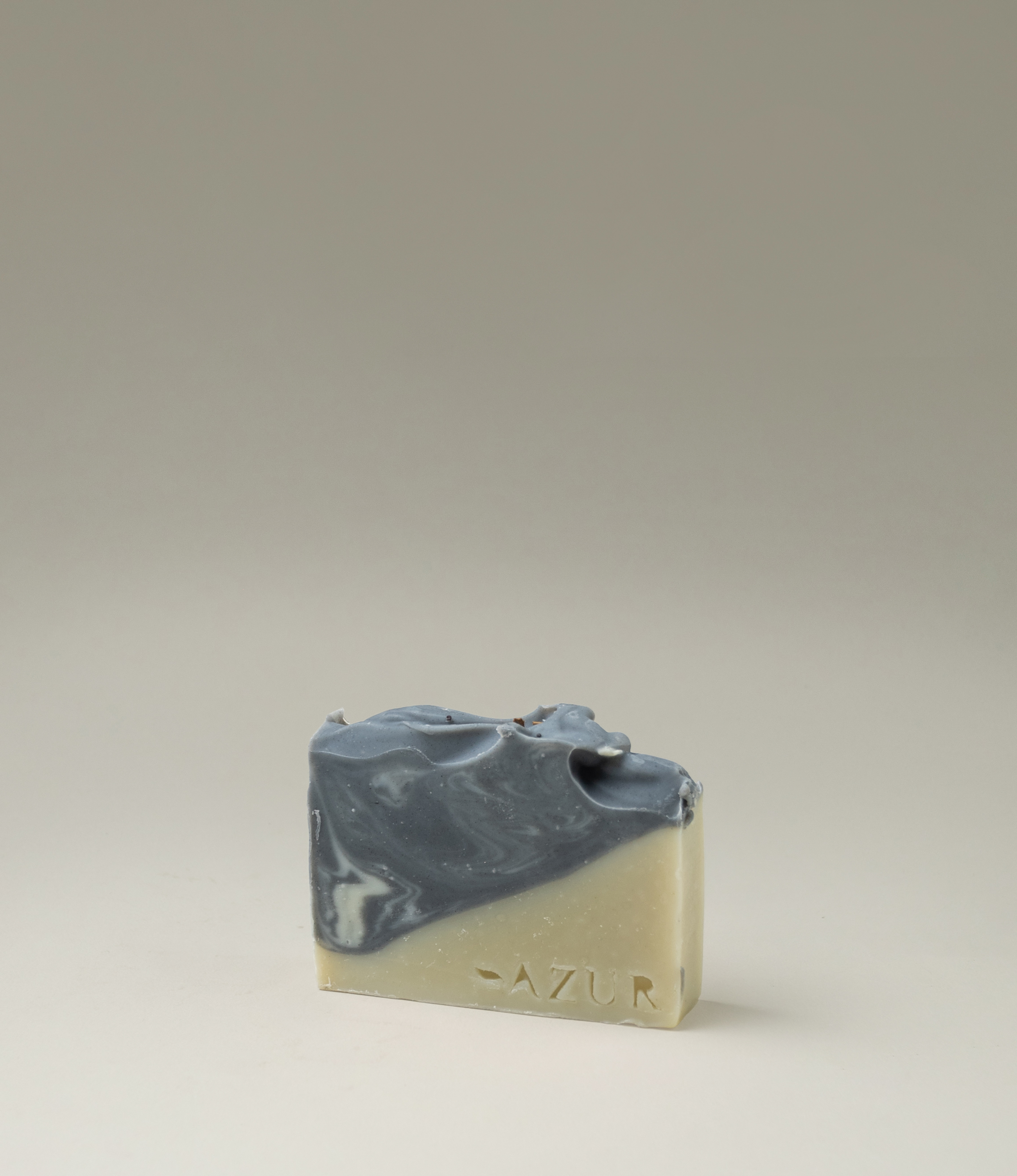 This soap has the scent of Wild Woods and it was crafted by Azur Natural Bodycare. The product merges two colors, light olive and dark grey. The top of the soap looks like the waves of the ocean. 