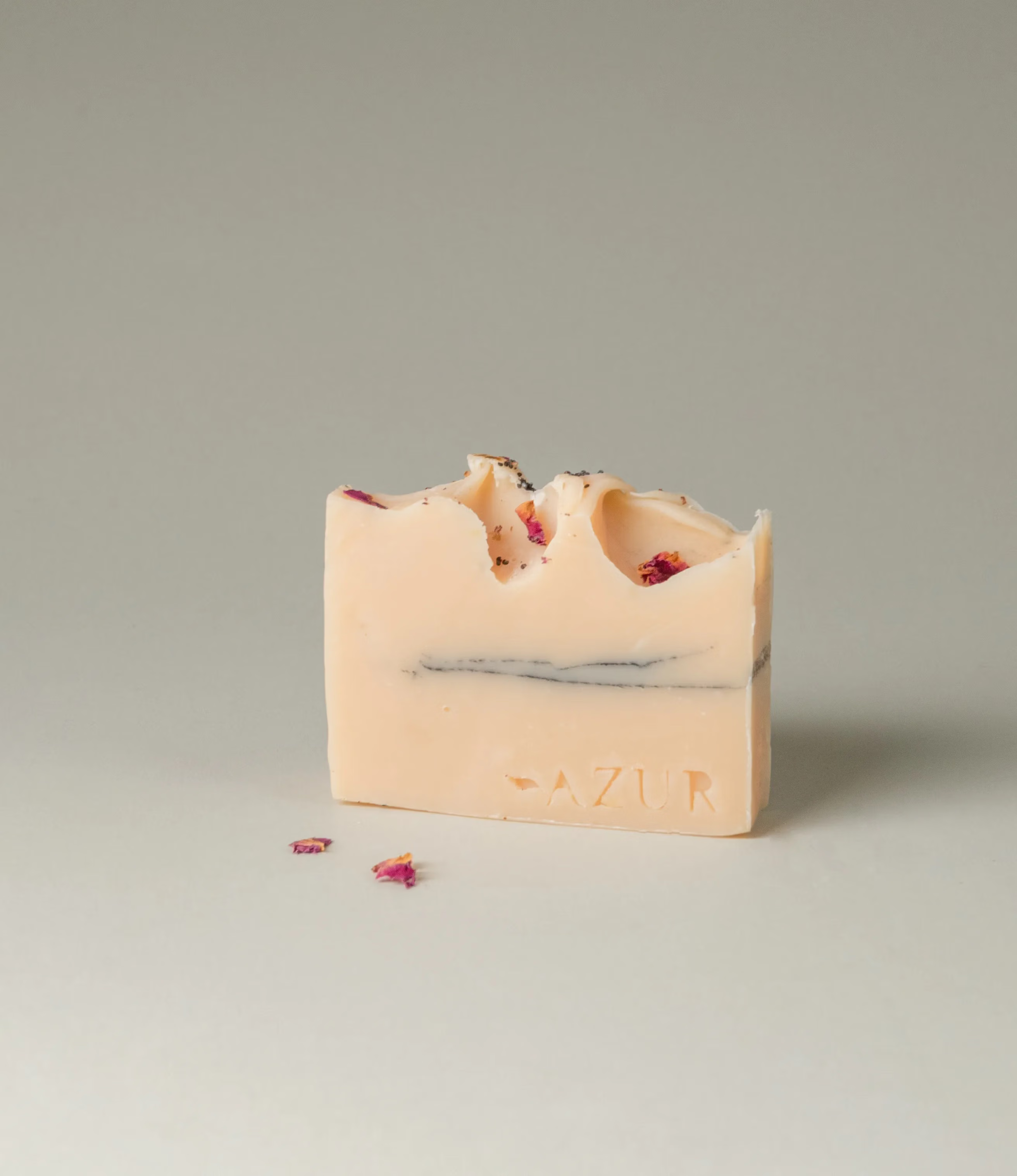 This soap has the scent of Wild Flower and it was crafted by Azur Natural Bodycare. The product merges two colors, light peach and dark grey. The top of the soap looks like the waves of the ocean and is hinted with petals.